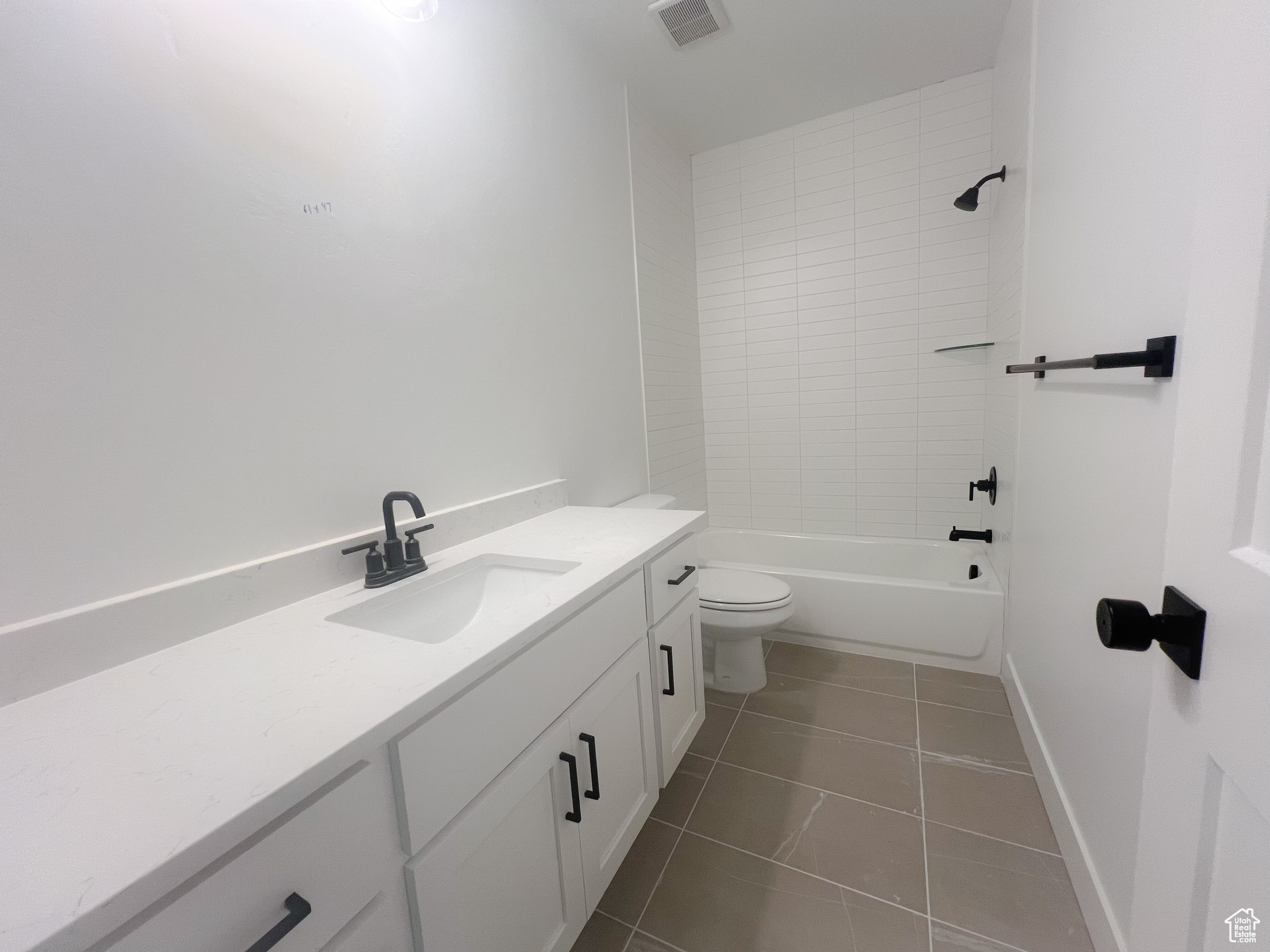 Full bathroom featuring vanity, toilet, tile patterned floors, and tiled shower / bath