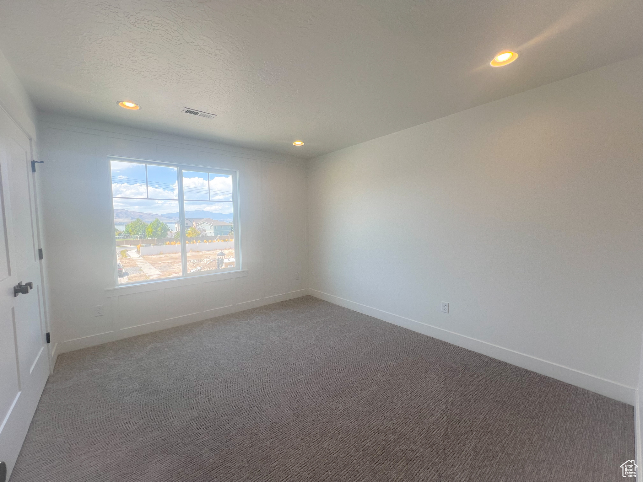 Spare room featuring a textured ceiling and carpet floors