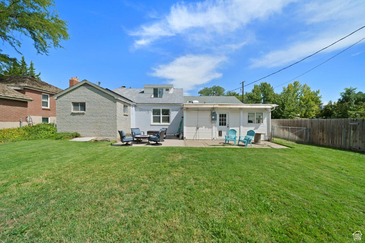 Back of house with a yard and a patio area