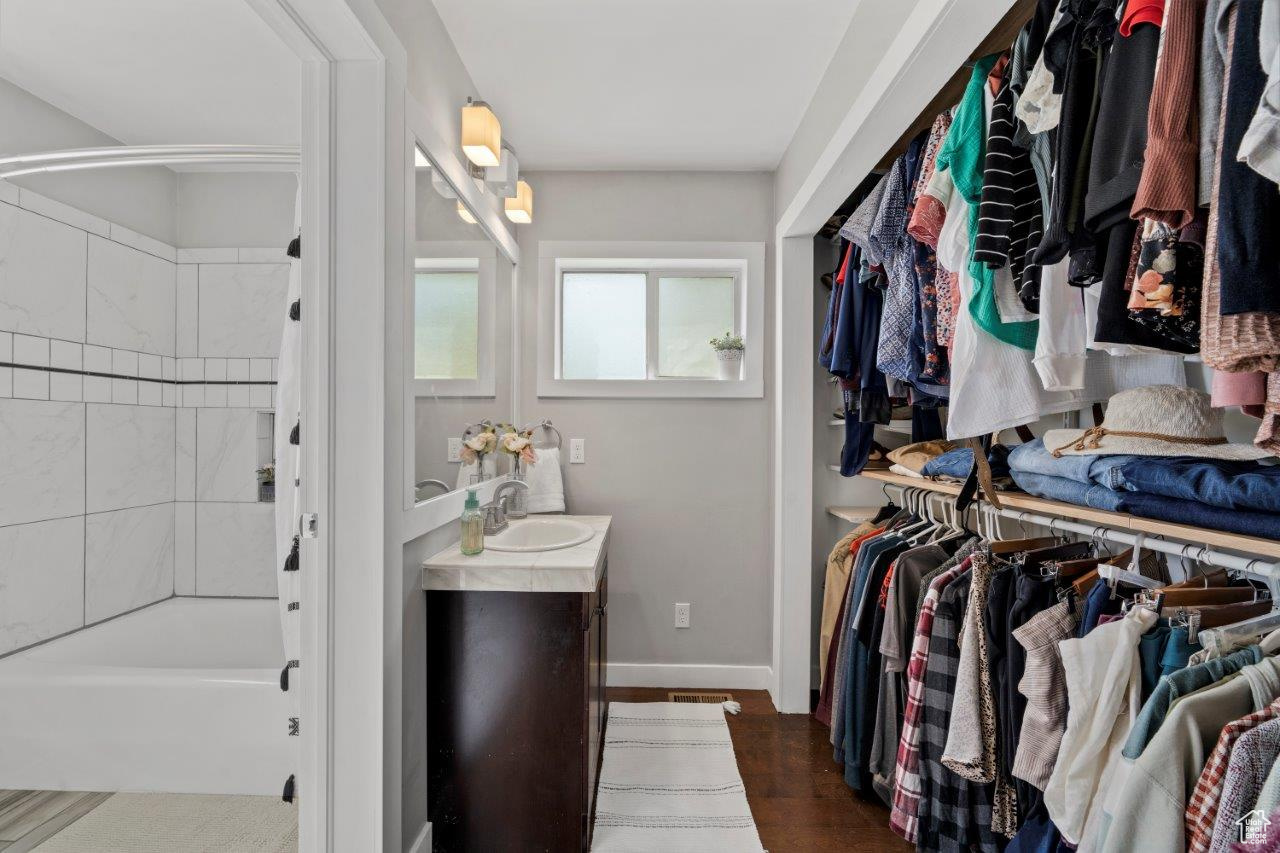 Spacious closet featuring dark wood-type flooring and sink