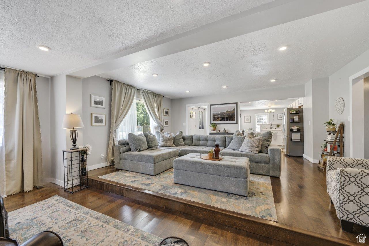 Living room featuring dark wood-type flooring and a textured ceiling