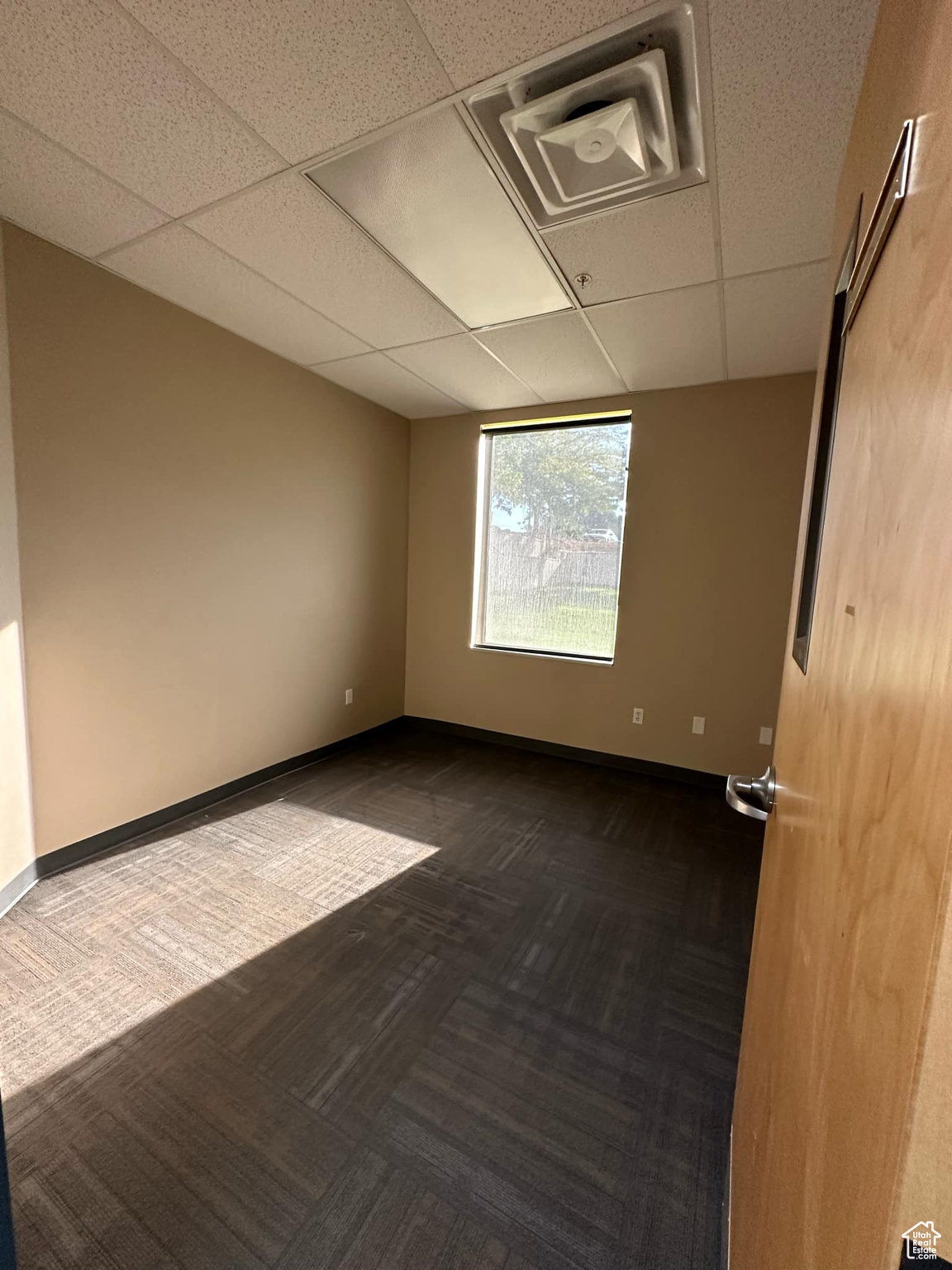 Carpeted spare room with a drop ceiling