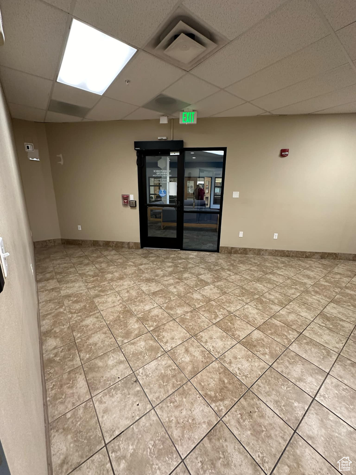 Tiled spare room featuring a drop ceiling