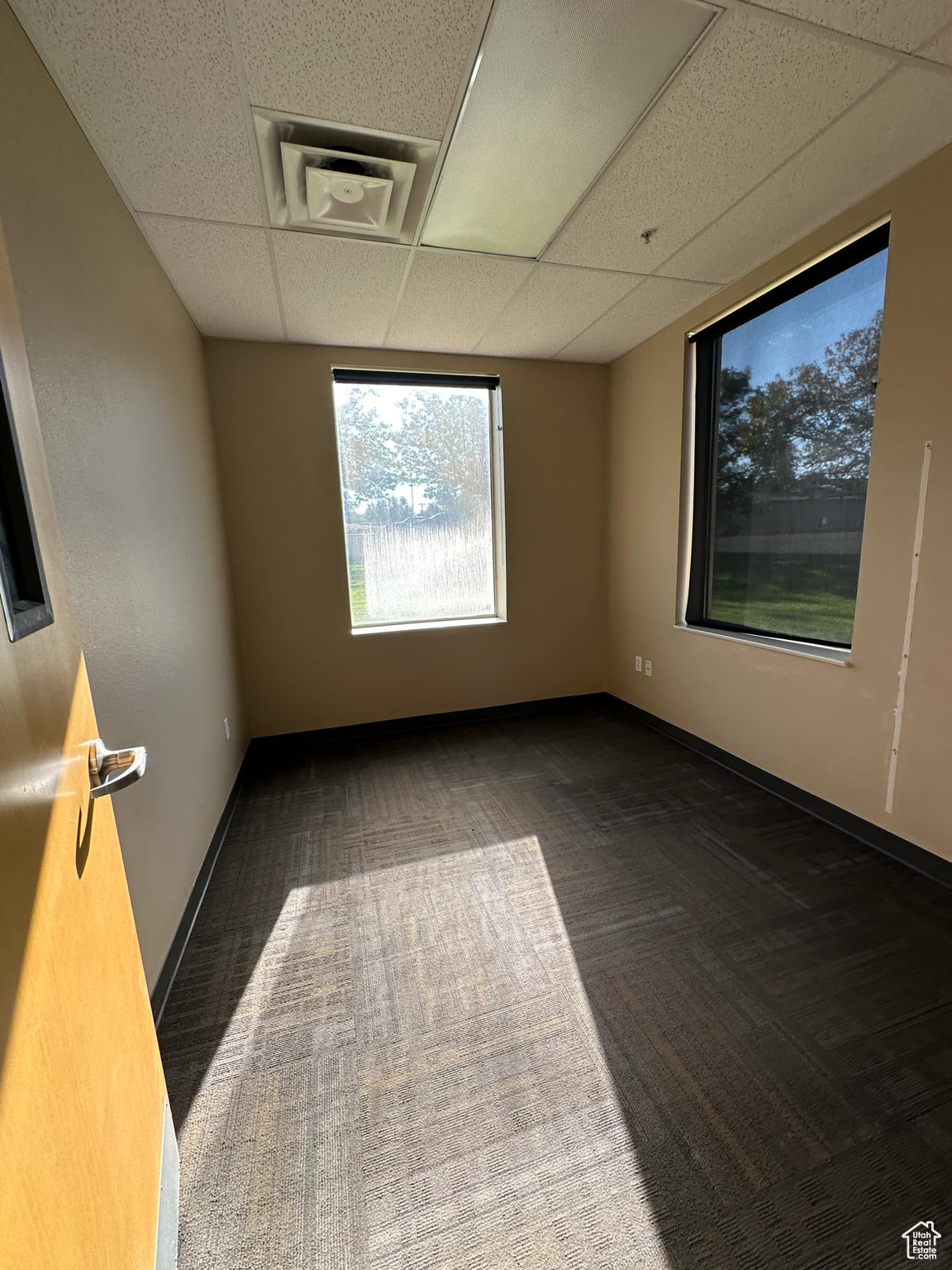 Unfurnished room with dark carpet and a paneled ceiling