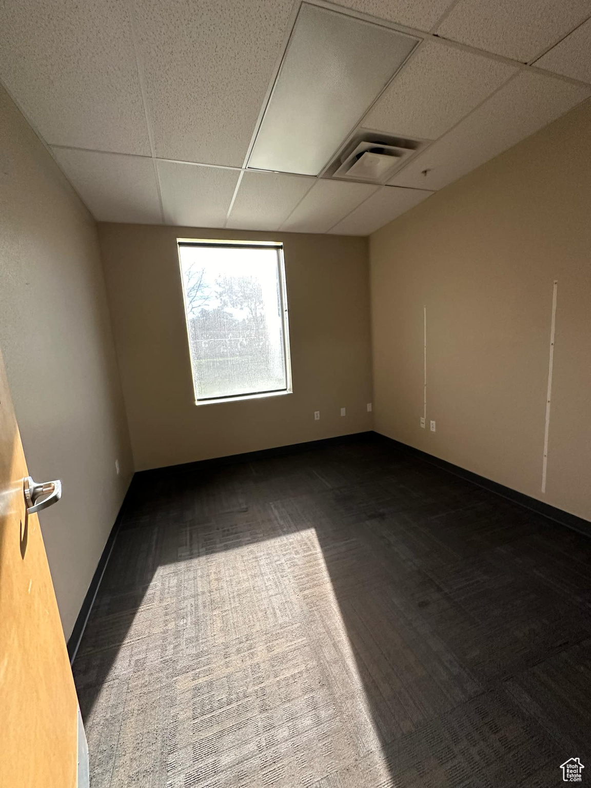 Carpeted spare room with a paneled ceiling