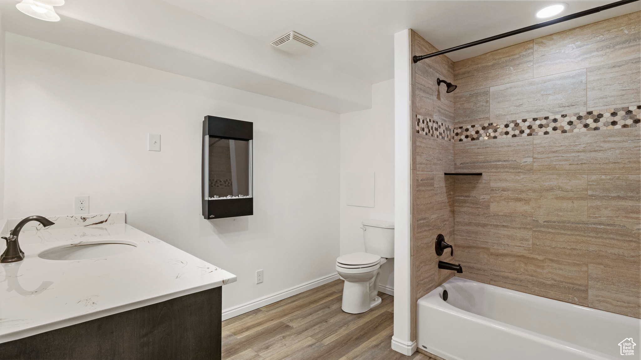 Full bathroom featuring vanity, toilet, hardwood / wood-style floors, and tiled shower / bath