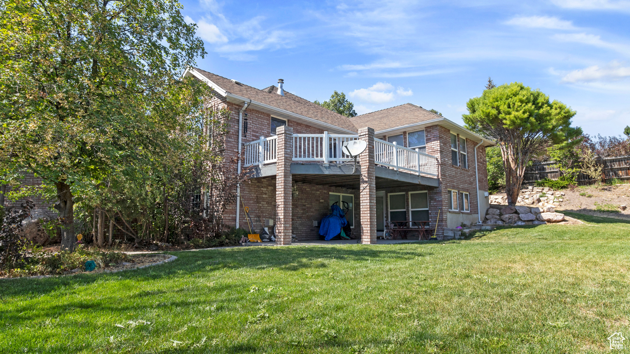 Rear view of house with a deck and a lawn