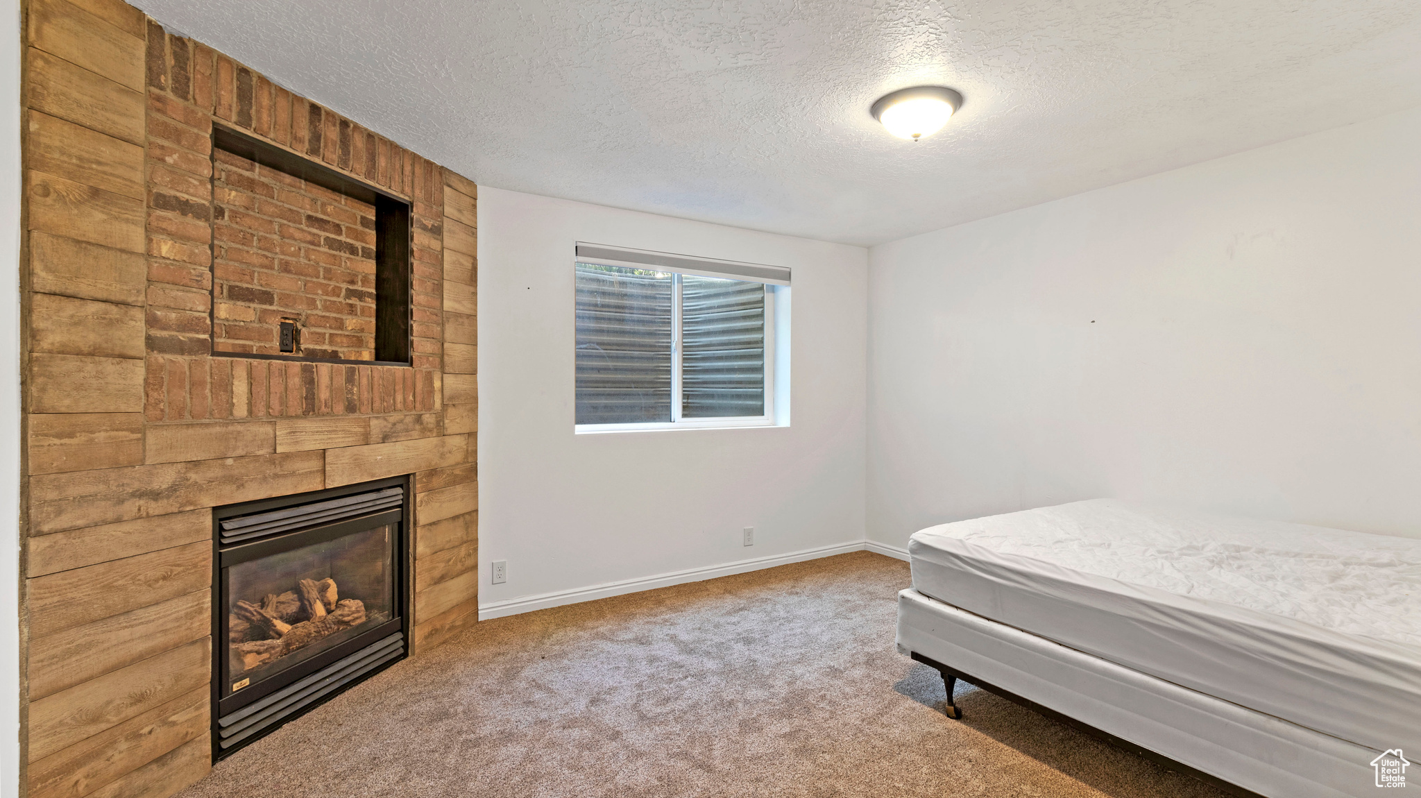 Bedroom featuring a textured ceiling, wooden walls, and carpet floors