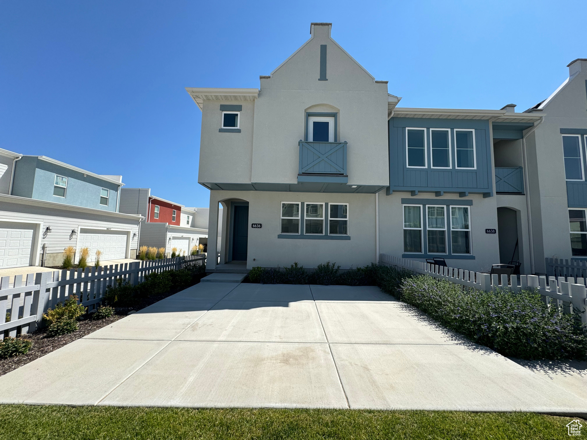 View of front of home featuring a garage and a balcony