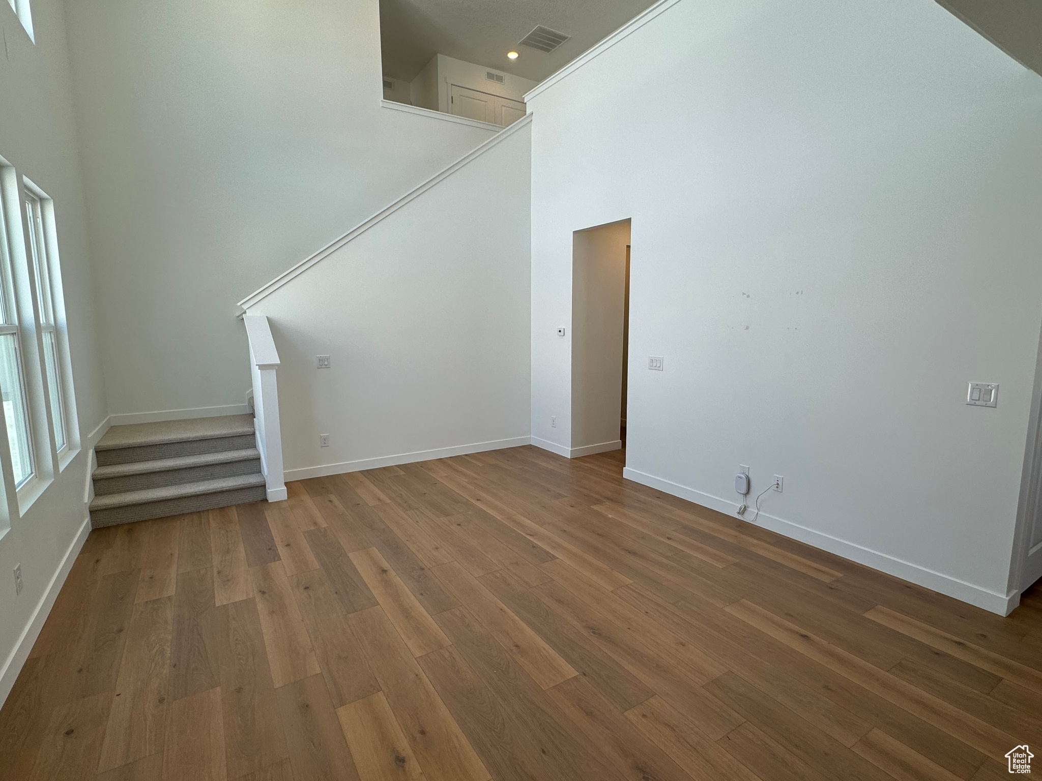 Interior space featuring a high ceiling and dark hardwood / wood-style floors