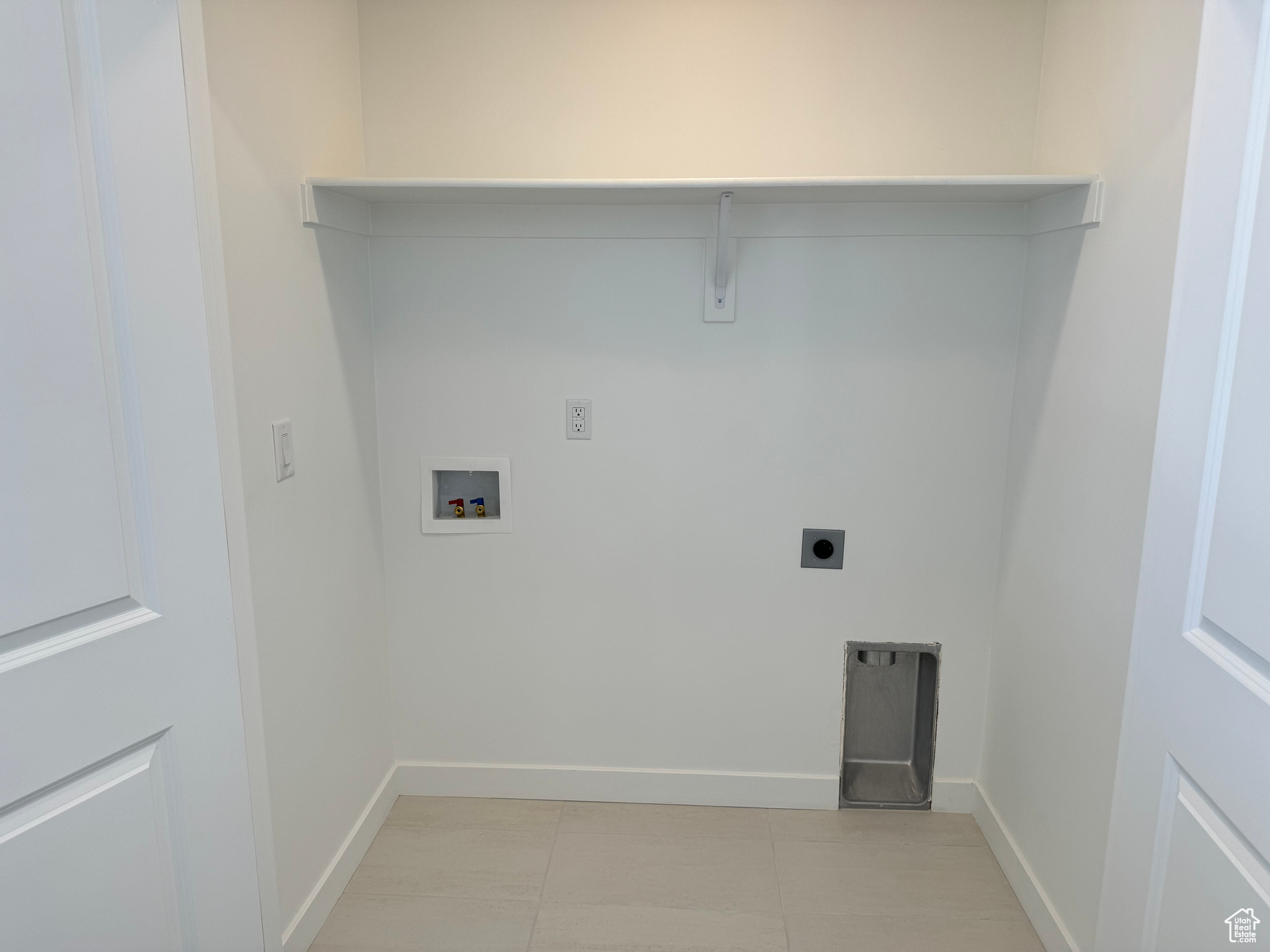 Laundry room featuring hookup for a washing machine, light tile patterned flooring, and electric dryer hookup