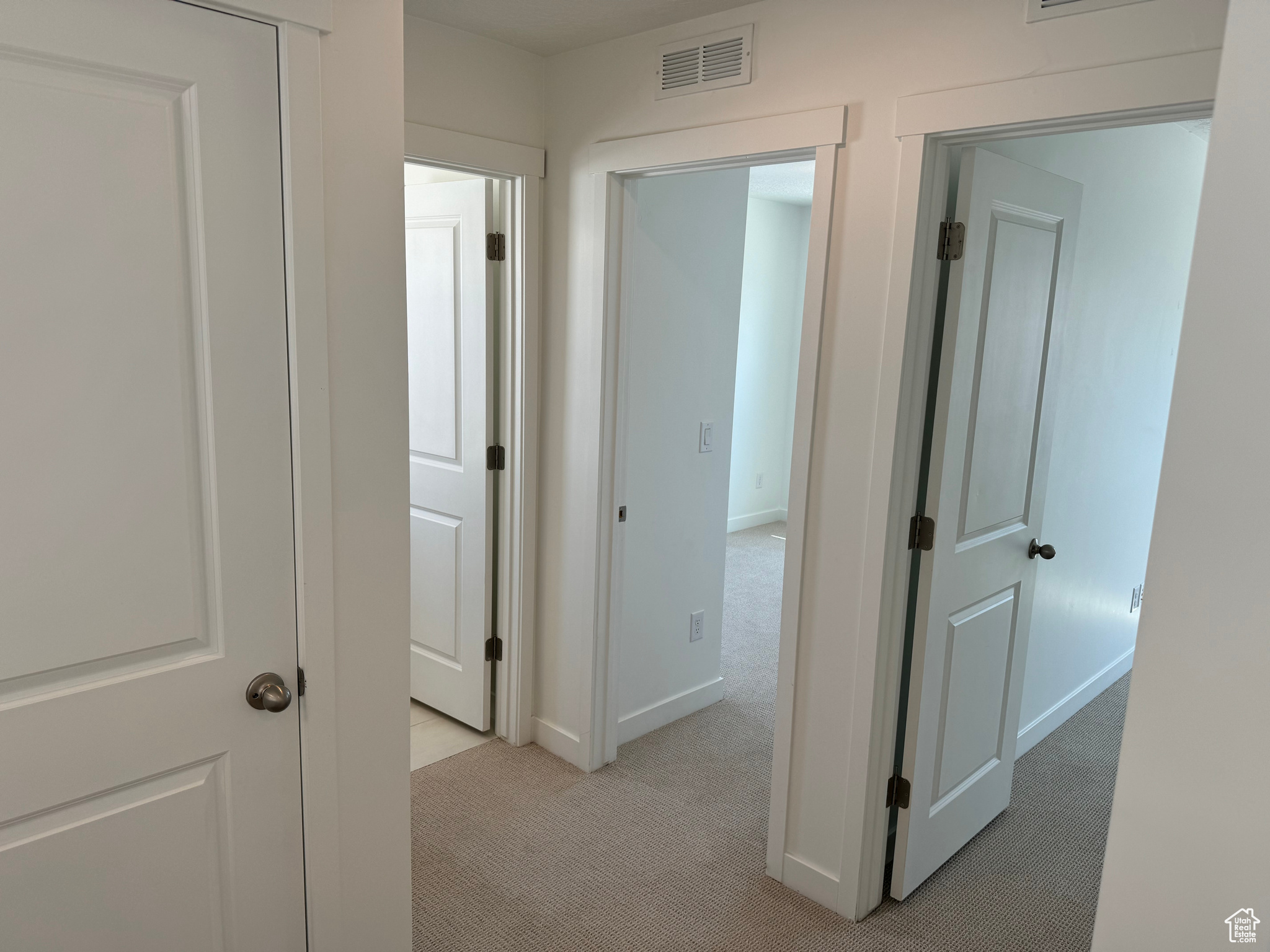 Hall featuring light colored carpet