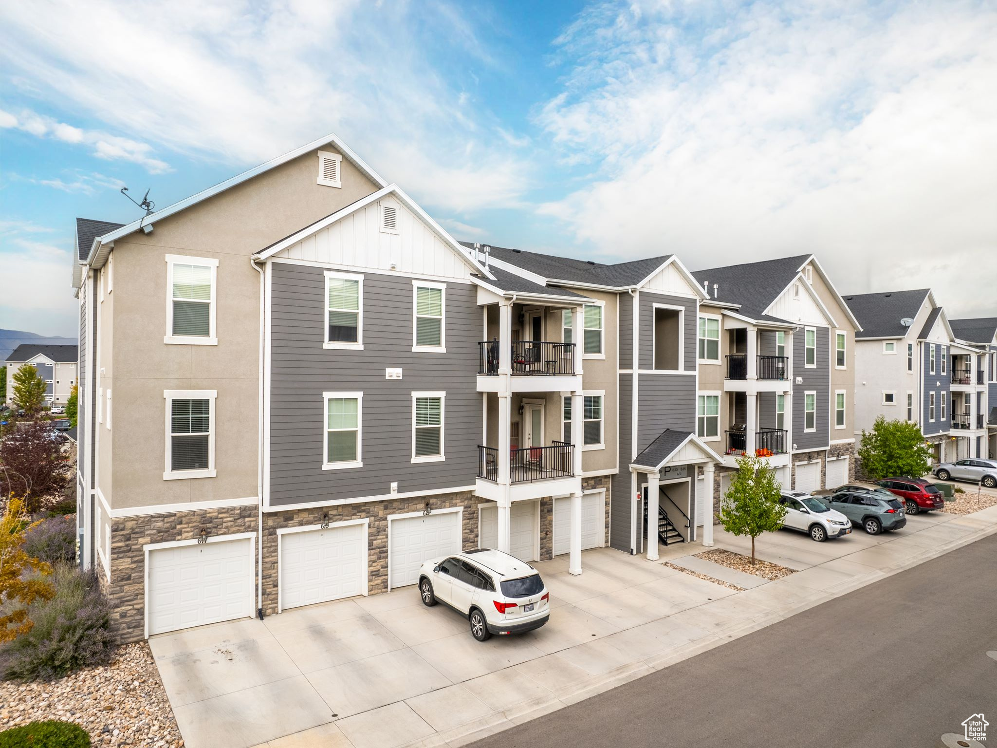 View of front of property featuring a garage and a balcony