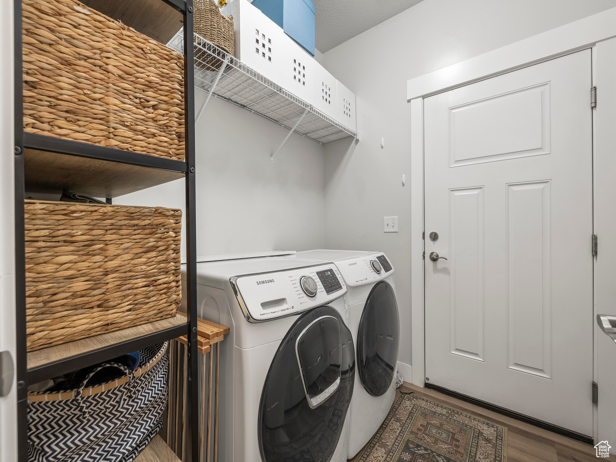 Laundry room with separate washer and dryer and hardwood / wood-style floors