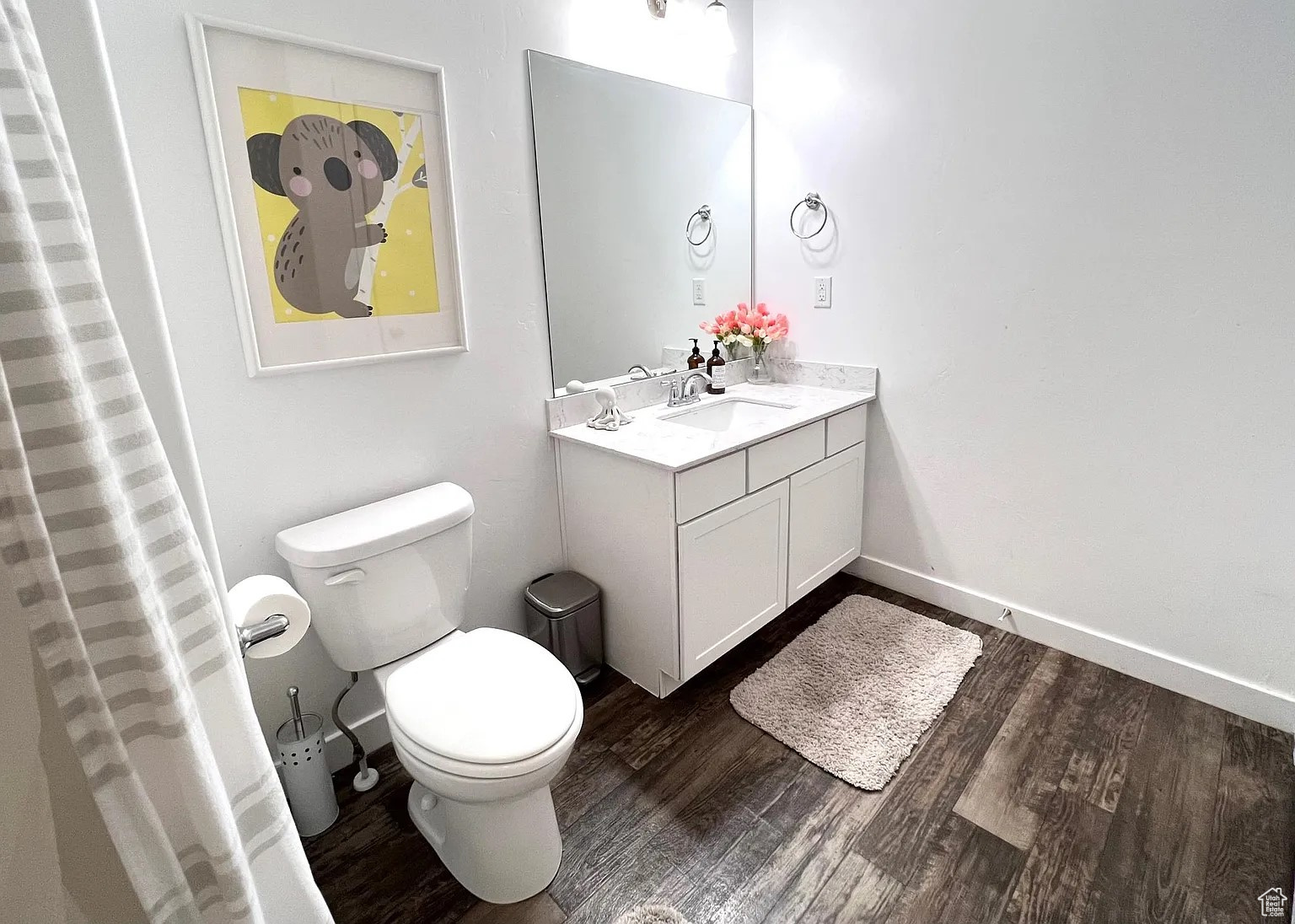 Bathroom with vanity, toilet, and dark vinyl flooring