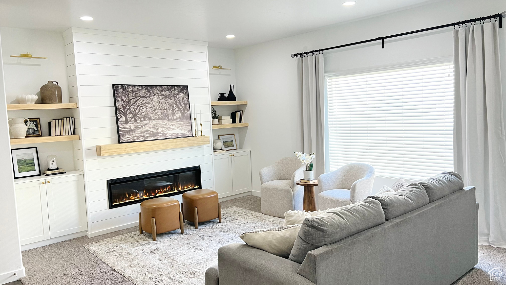 Living room featuring a fireplace, light colored carpet, and plenty of natural light