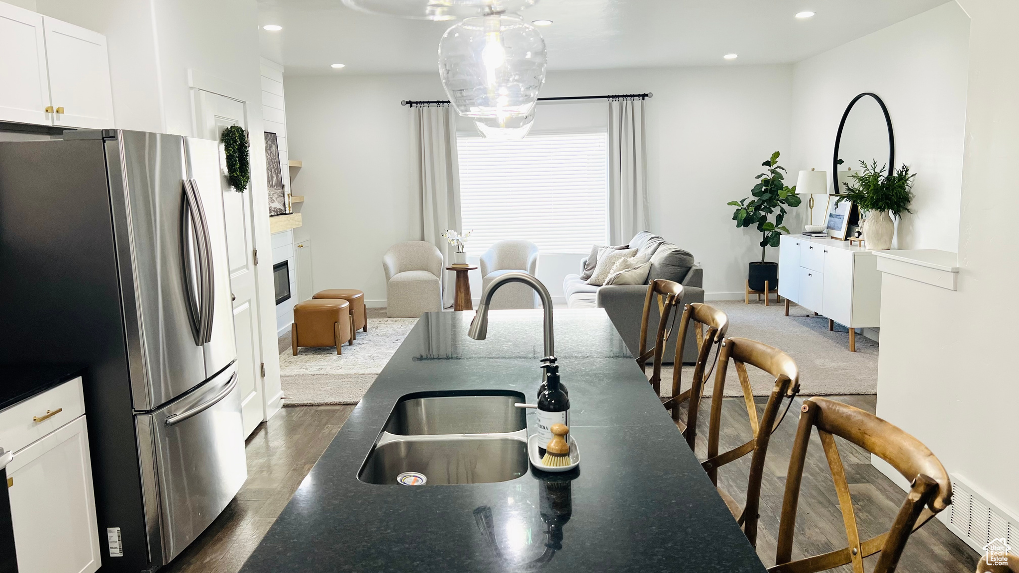 Kitchen with white cabinetry, stainless steel fridge, and sink