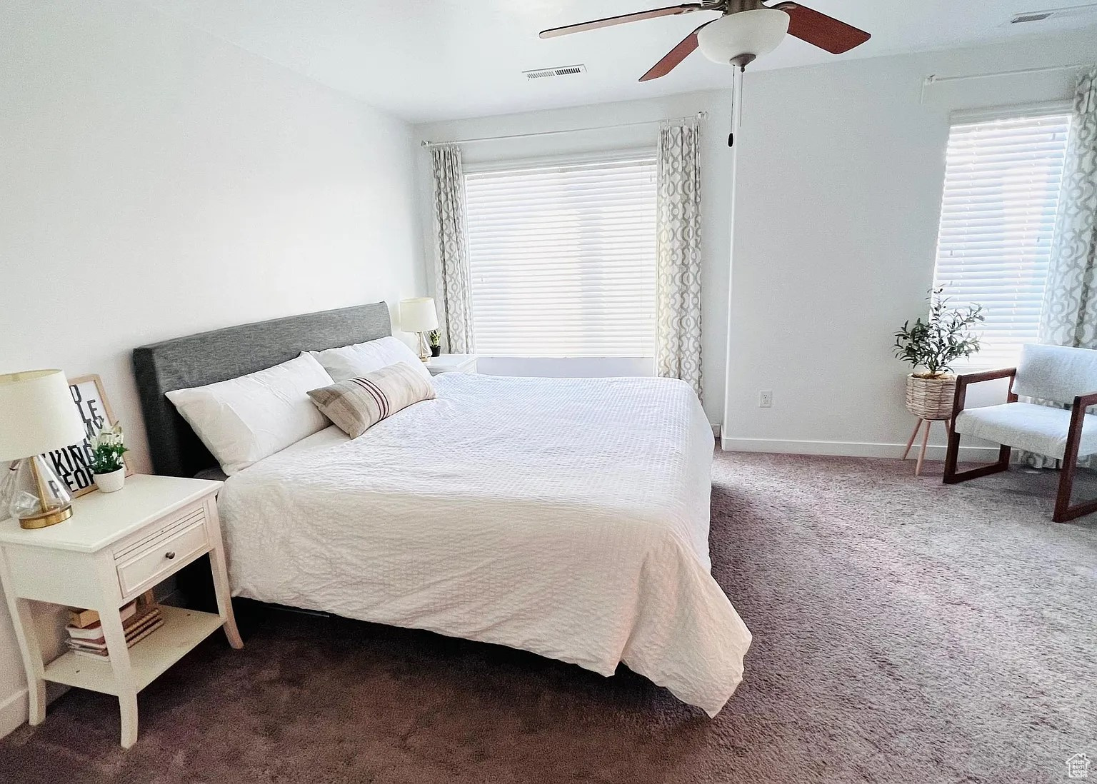 Carpeted bedroom featuring ceiling fan