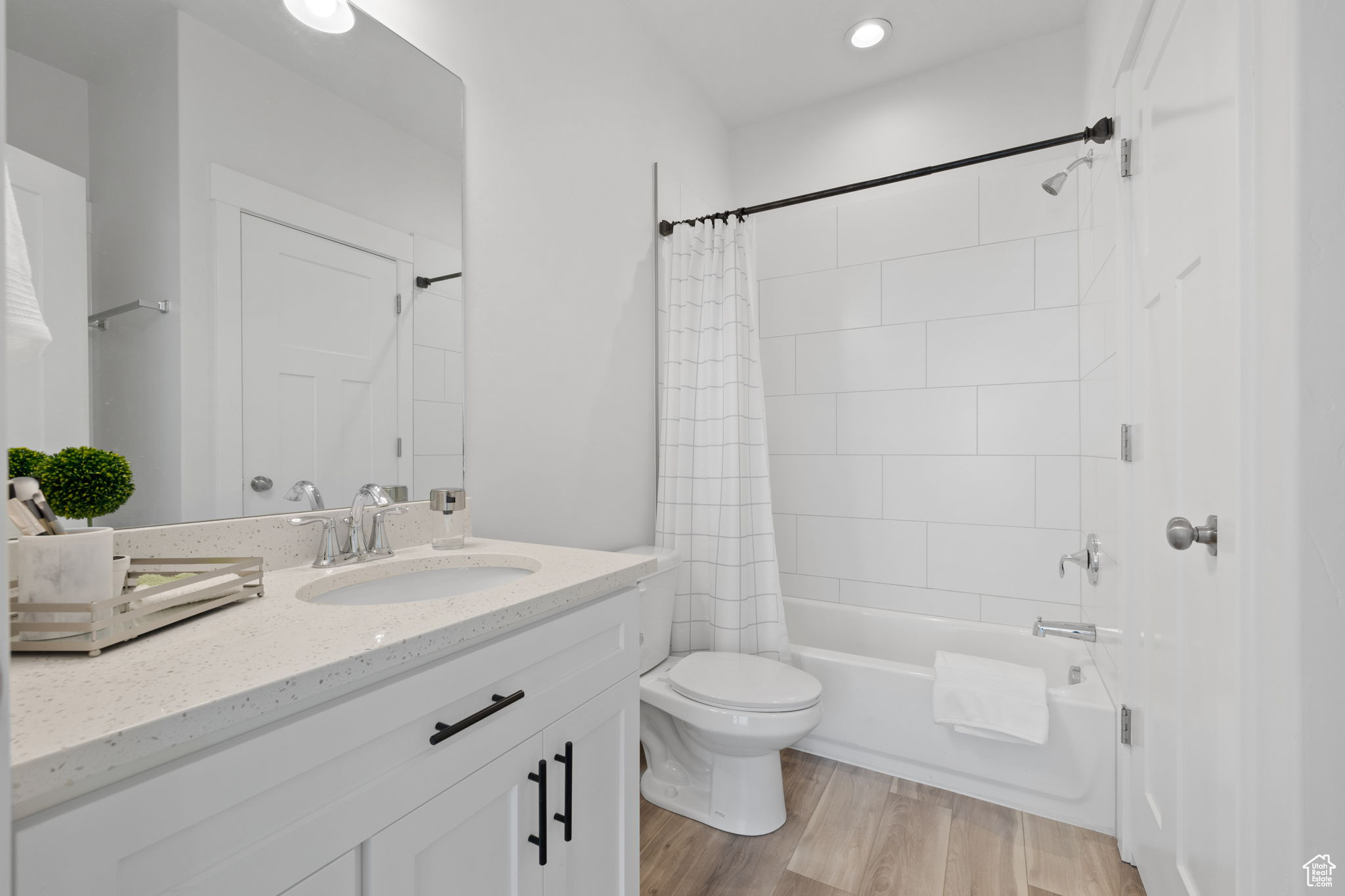 Full bathroom featuring vanity, toilet, wood-type flooring, and shower / bath combo