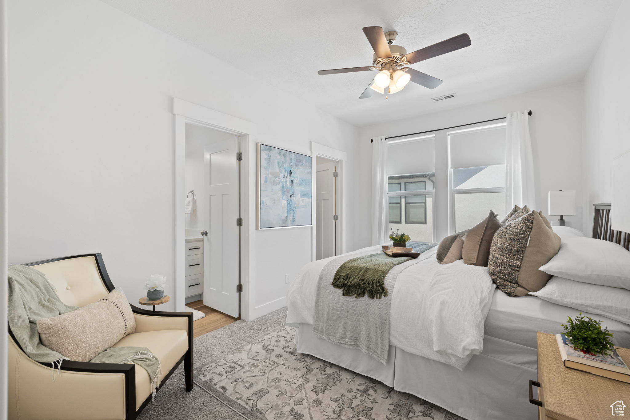 Bedroom with light hardwood / wood-style flooring, ceiling fan, and ensuite bathroom