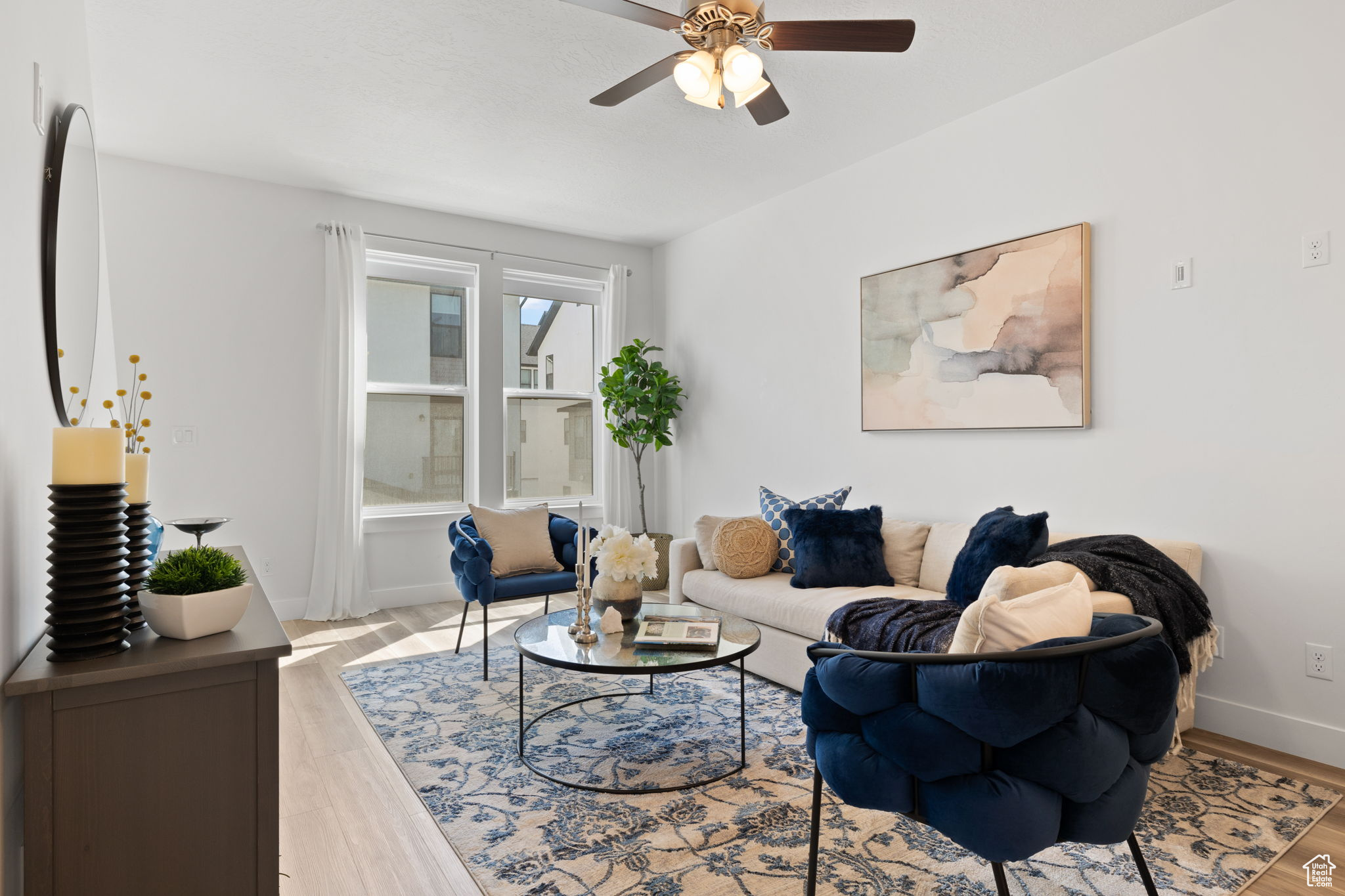 Living room with ceiling fan and light hardwood / wood-style flooring