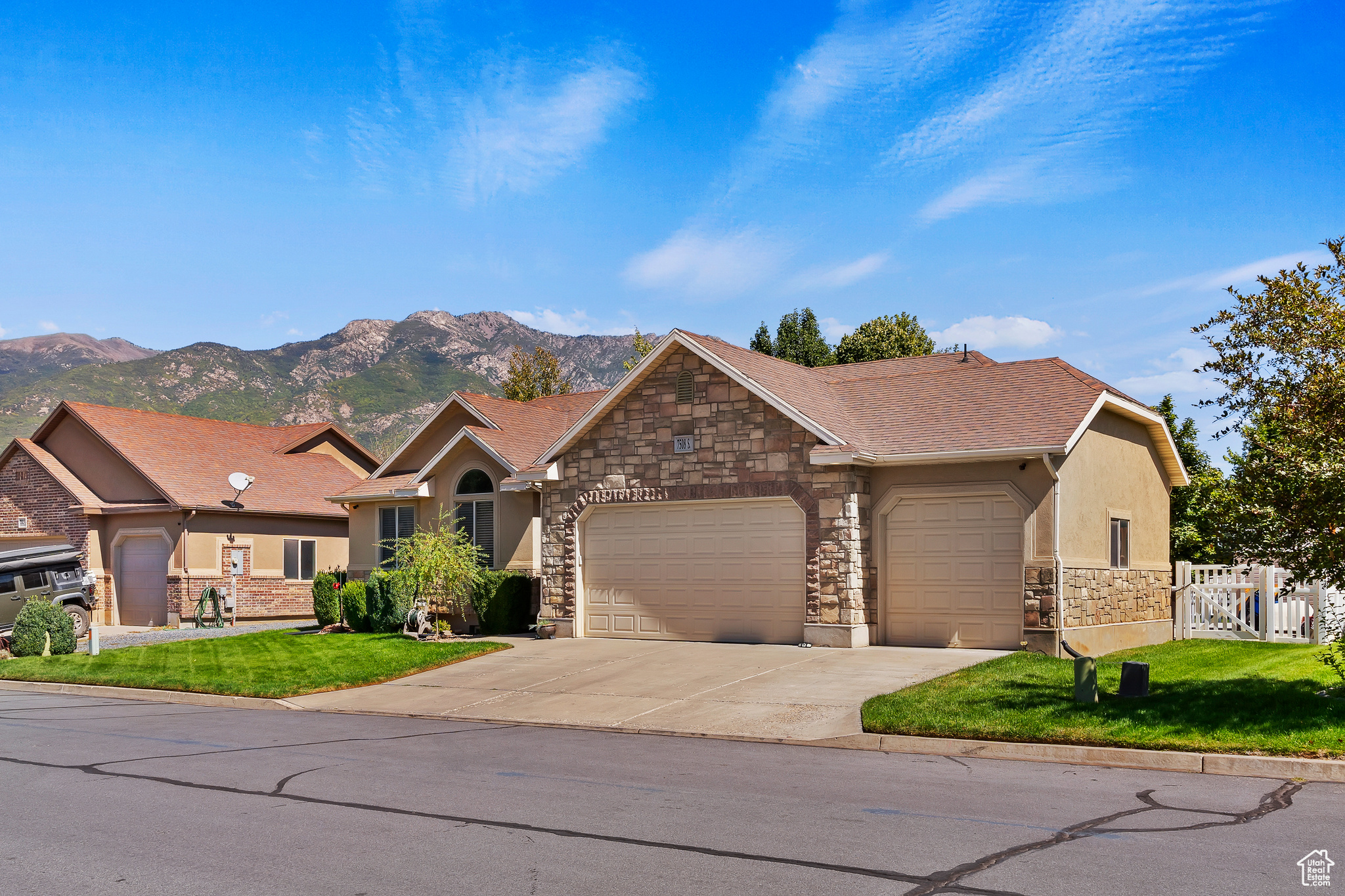 View of front facade featuring a mountain view, a front yard, and a garage