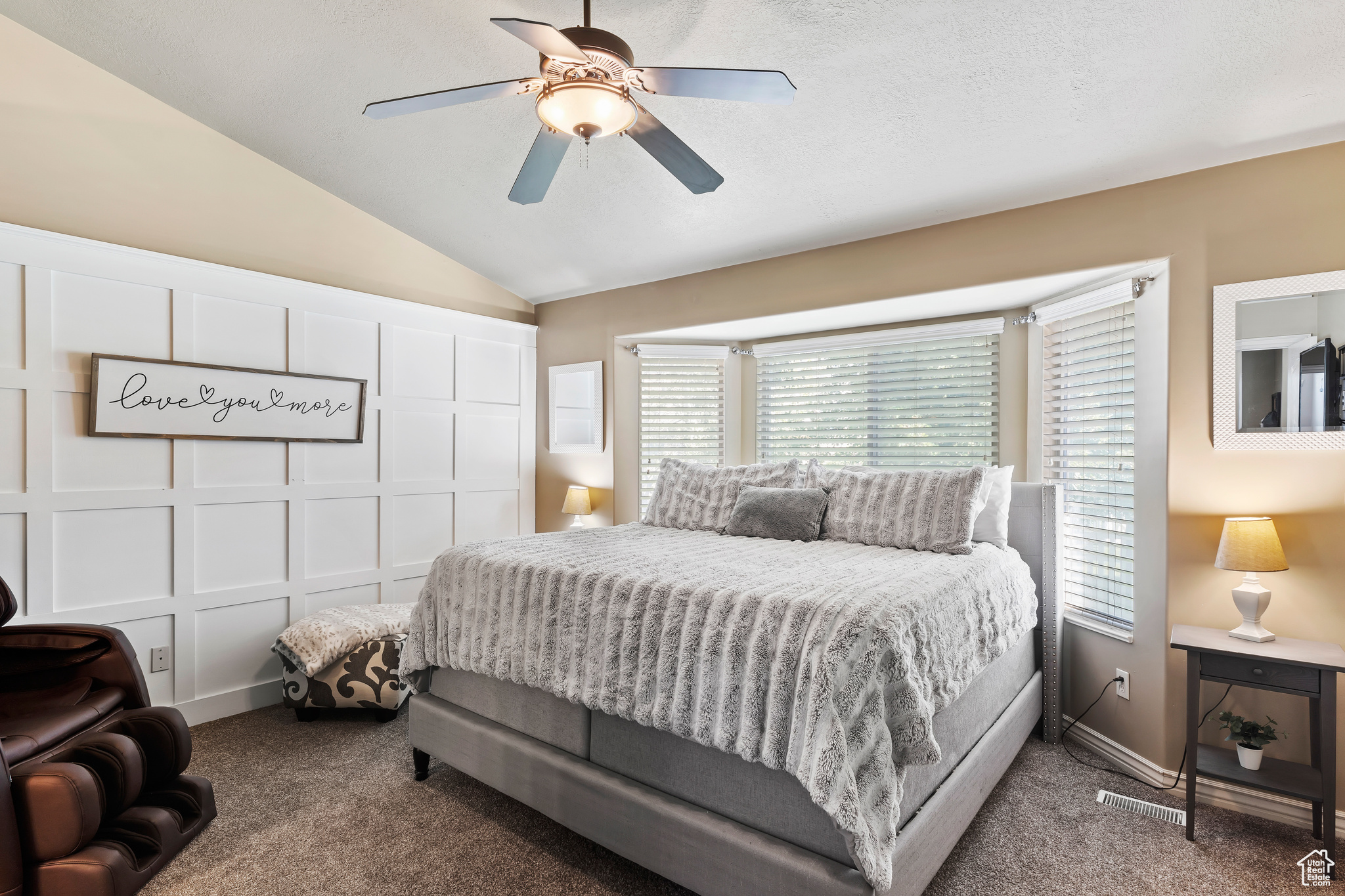 Carpeted bedroom featuring vaulted ceiling and ceiling fan