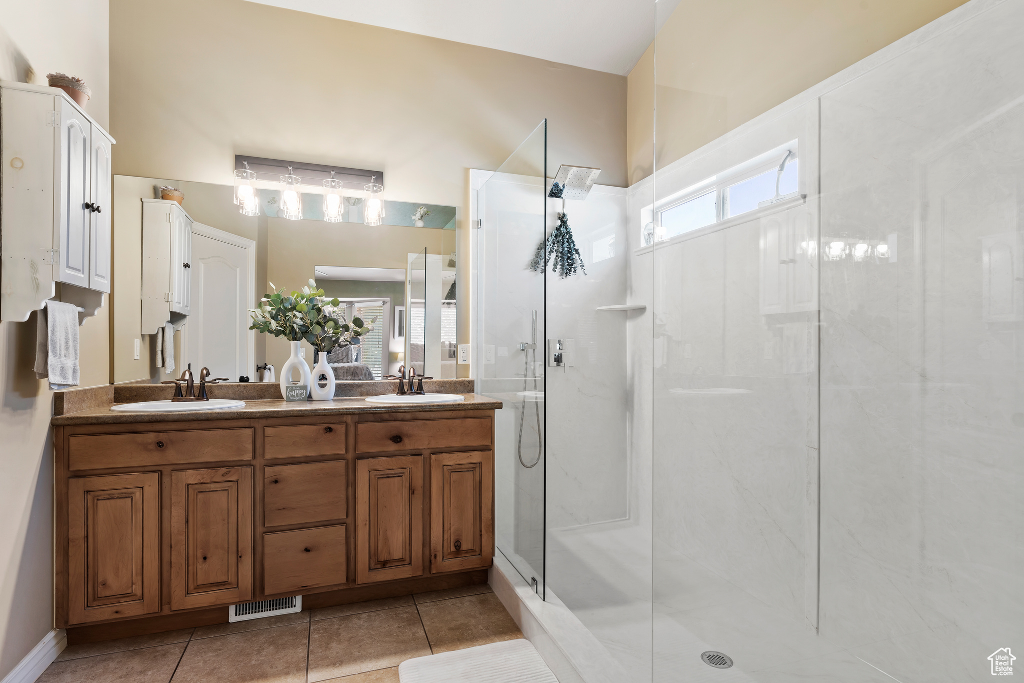 Bathroom featuring vanity, tile patterned floors, and a shower with shower door