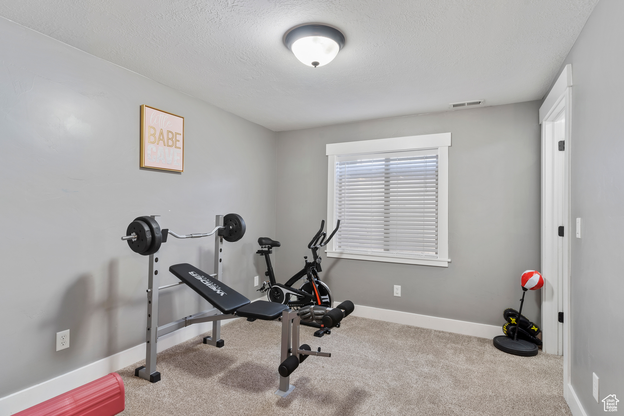 Workout area featuring a textured ceiling and light colored carpet