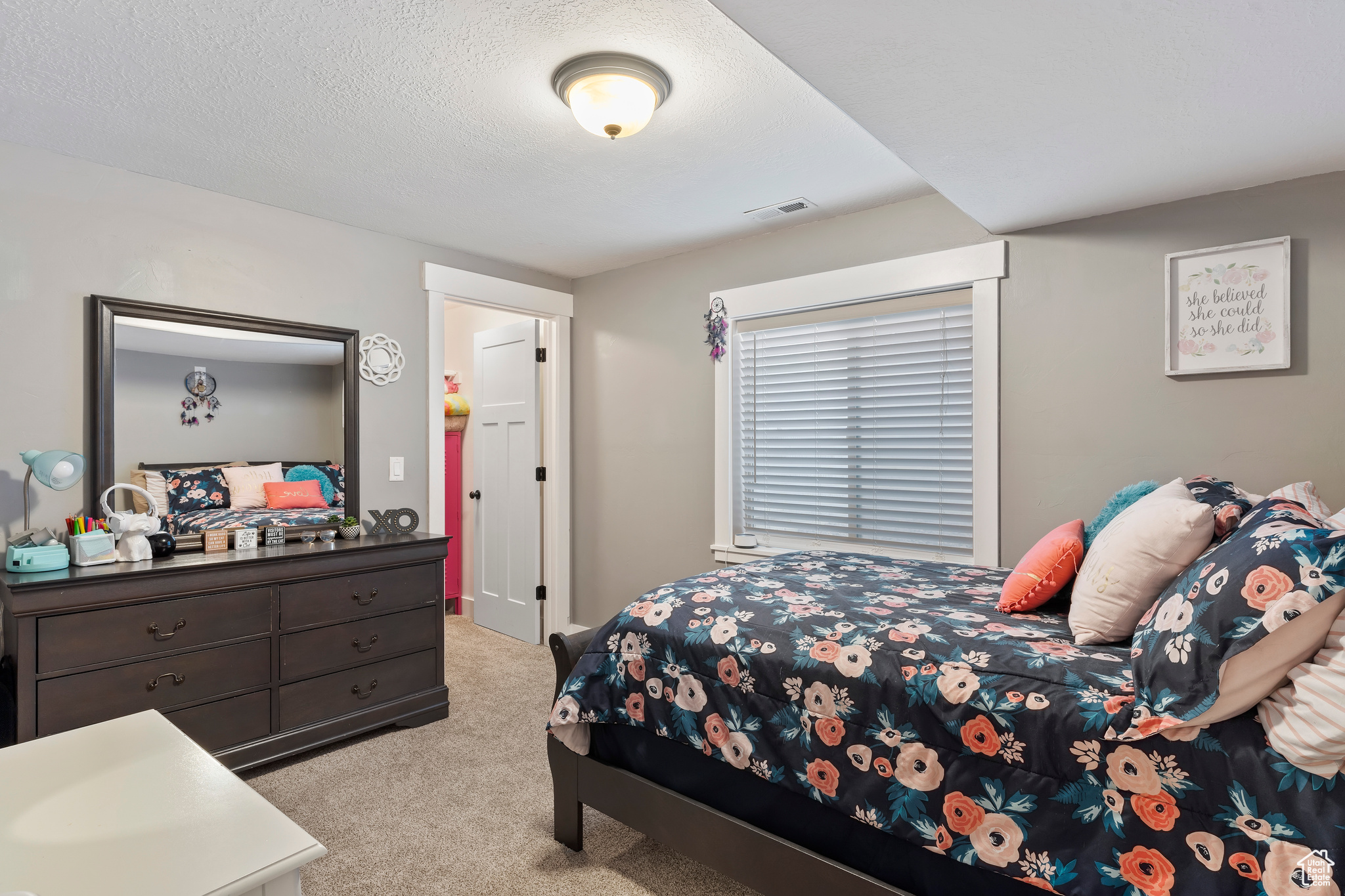 Bedroom featuring light carpet and a textured ceiling