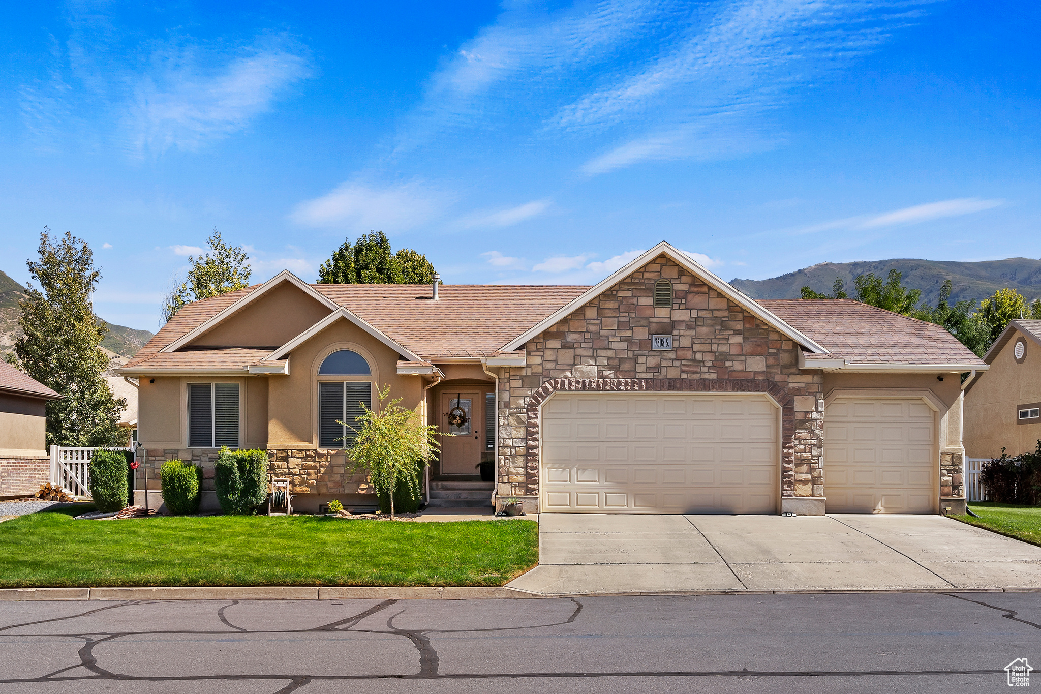 Single story home with a front yard, a mountain view, and a garage