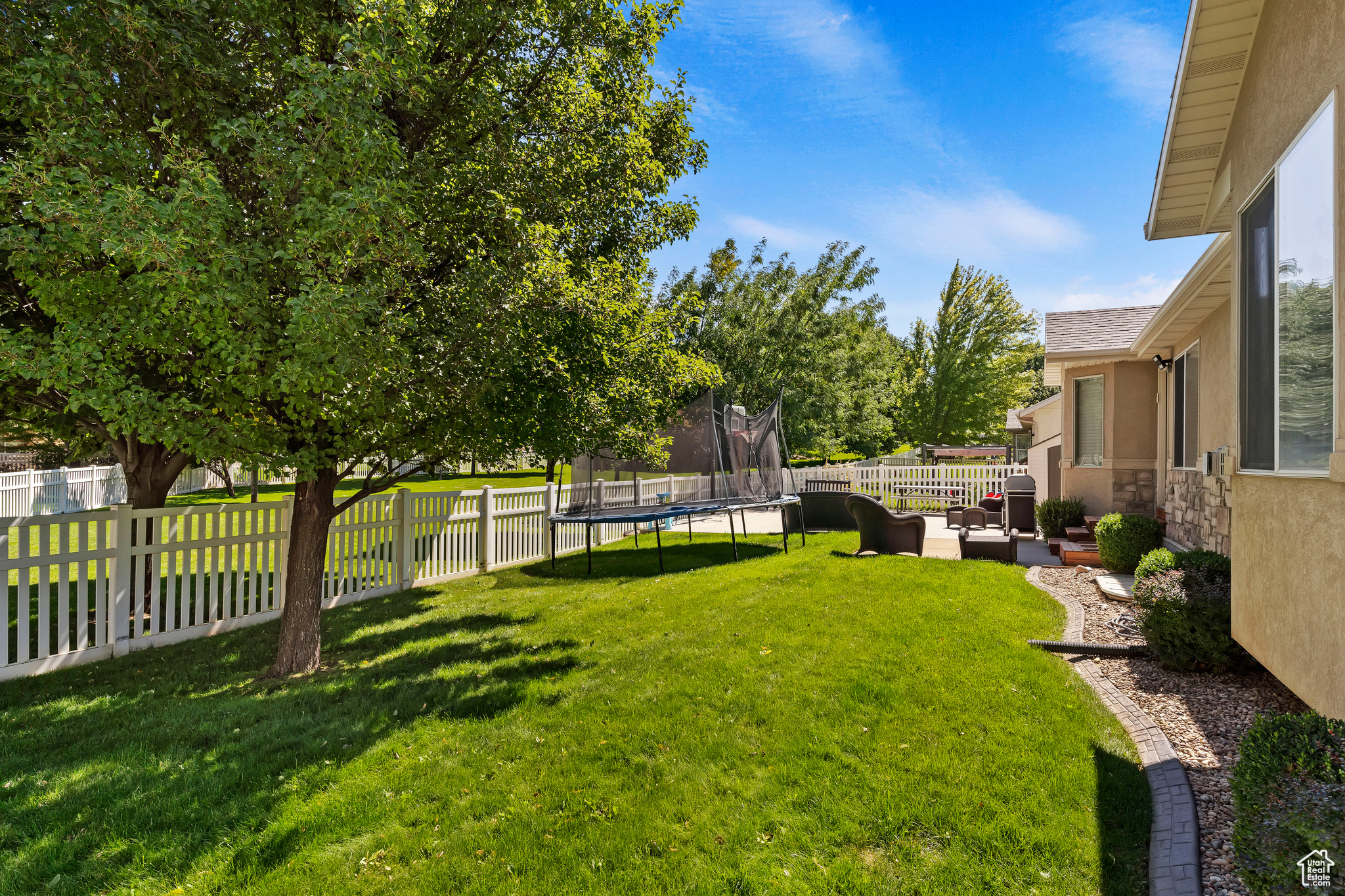 View of yard with a trampoline and a patio