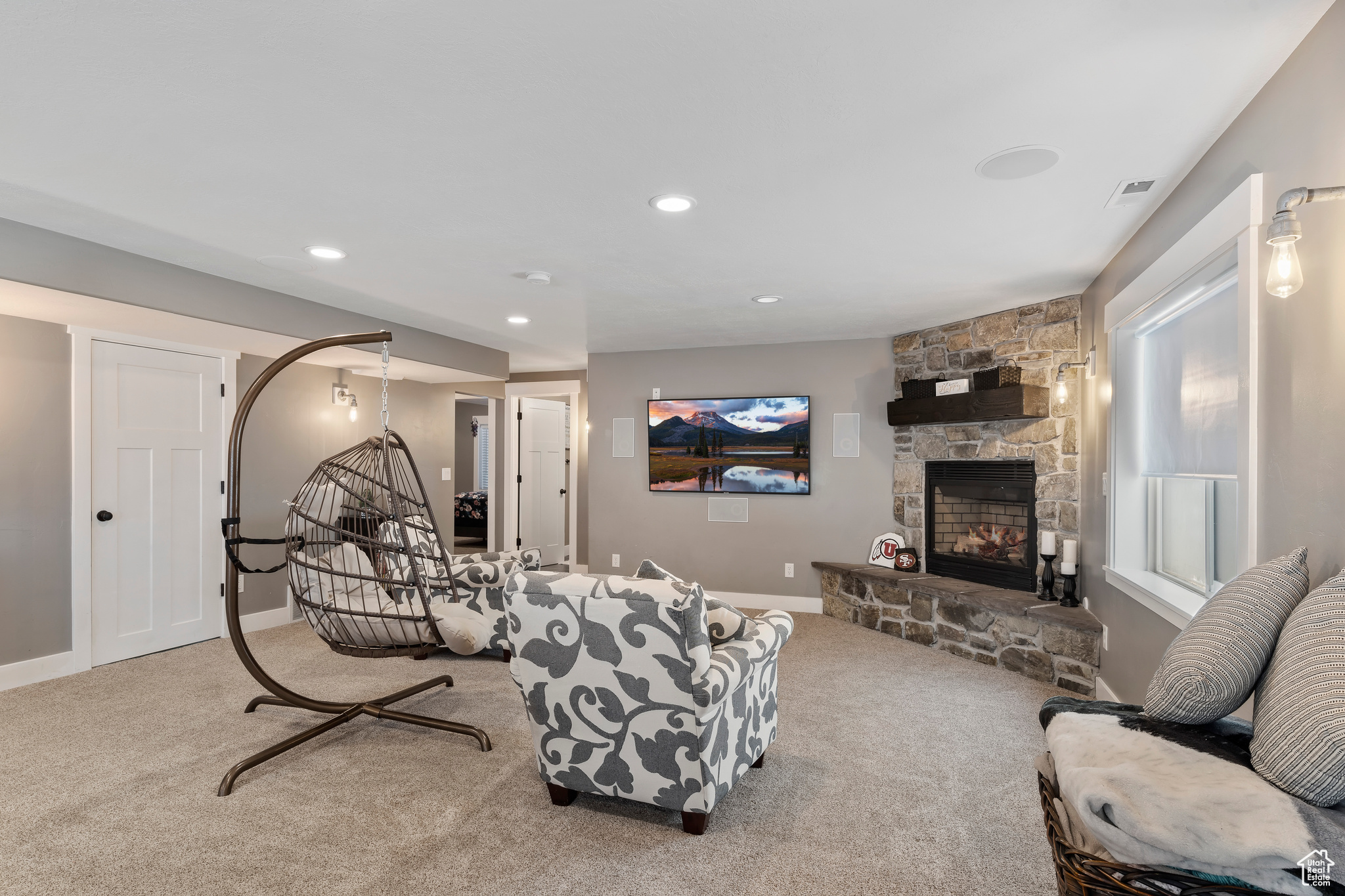 Living room featuring carpet floors and a stone fireplace