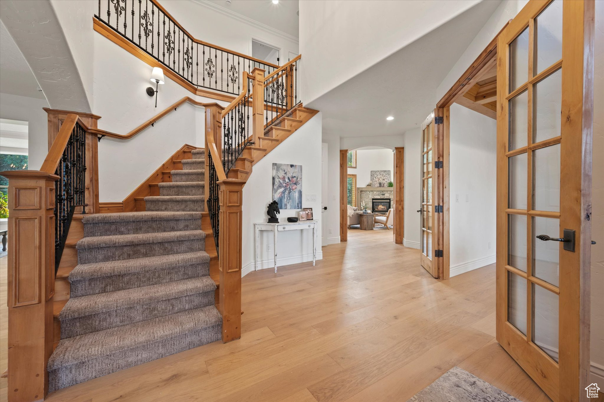 Stairway with crown molding, french doors, and hardwood / wood-style flooring