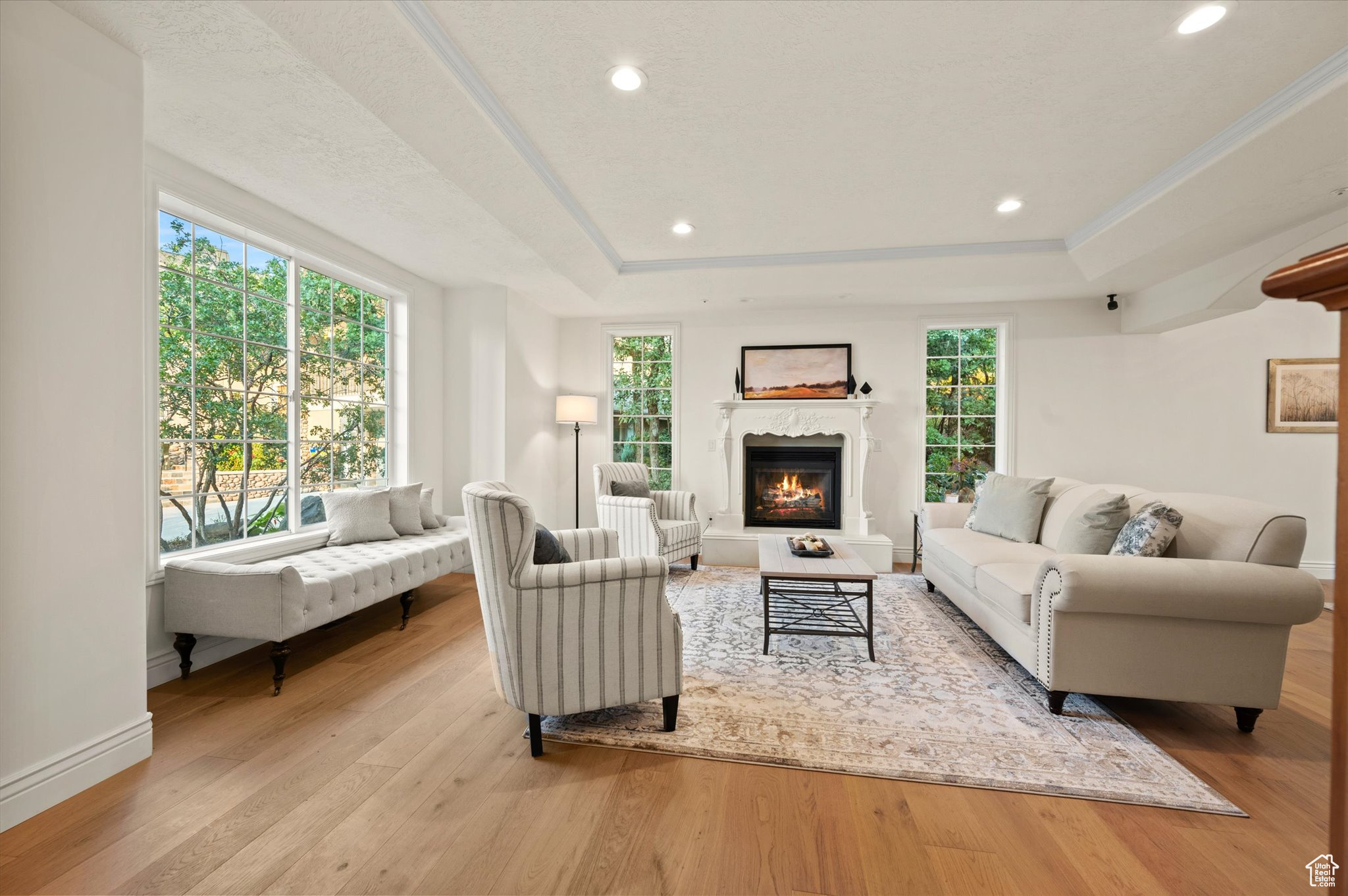 Living room with a wealth of natural light, a fireplace, and light hardwood / wood-style floors