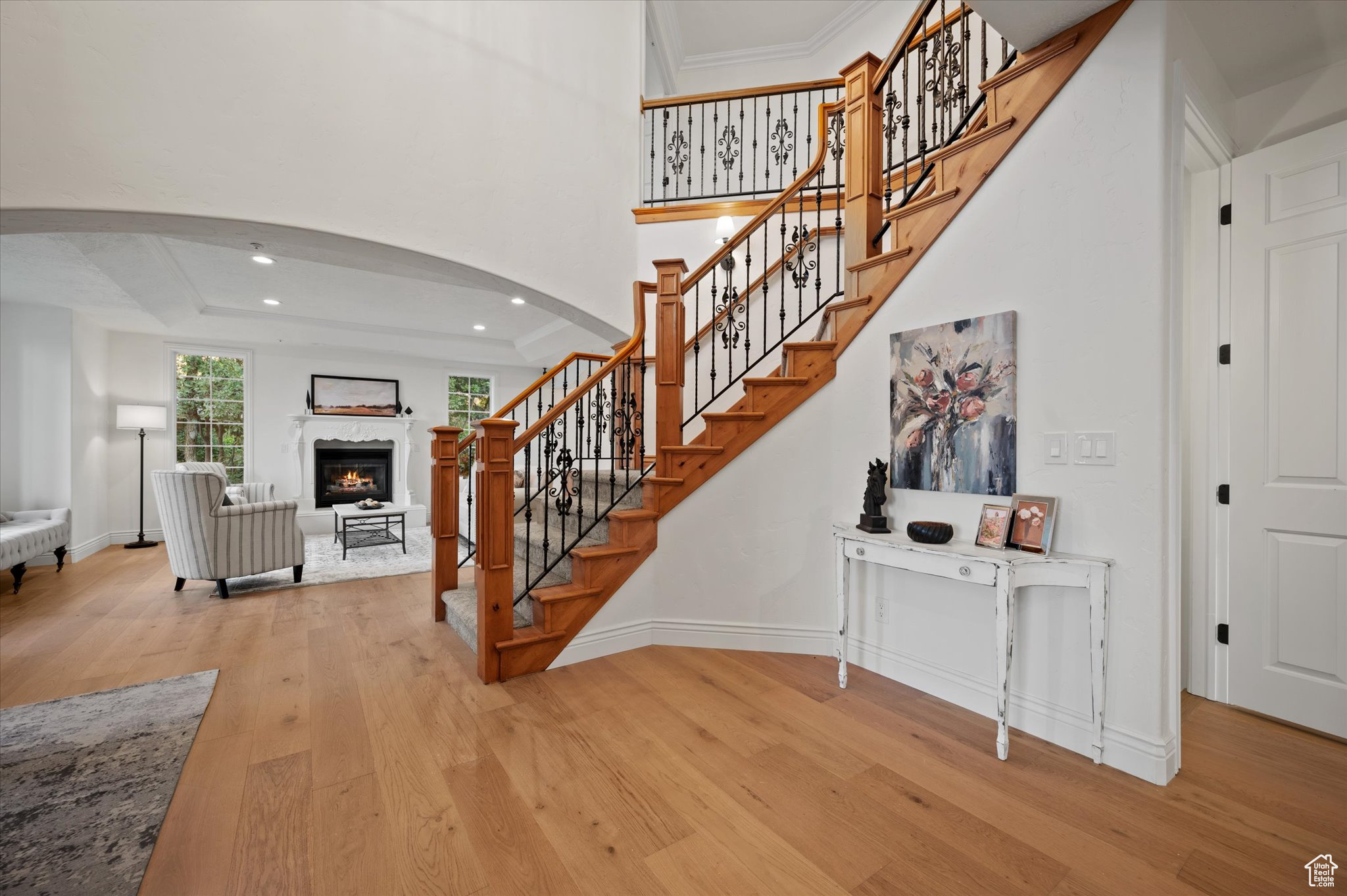 Stairs with a high end fireplace, ornamental molding, and hardwood / wood-style flooring