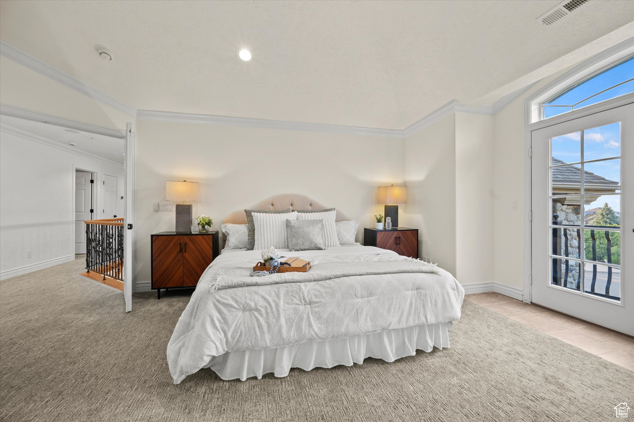 Carpeted bedroom with crown molding and vaulted ceiling