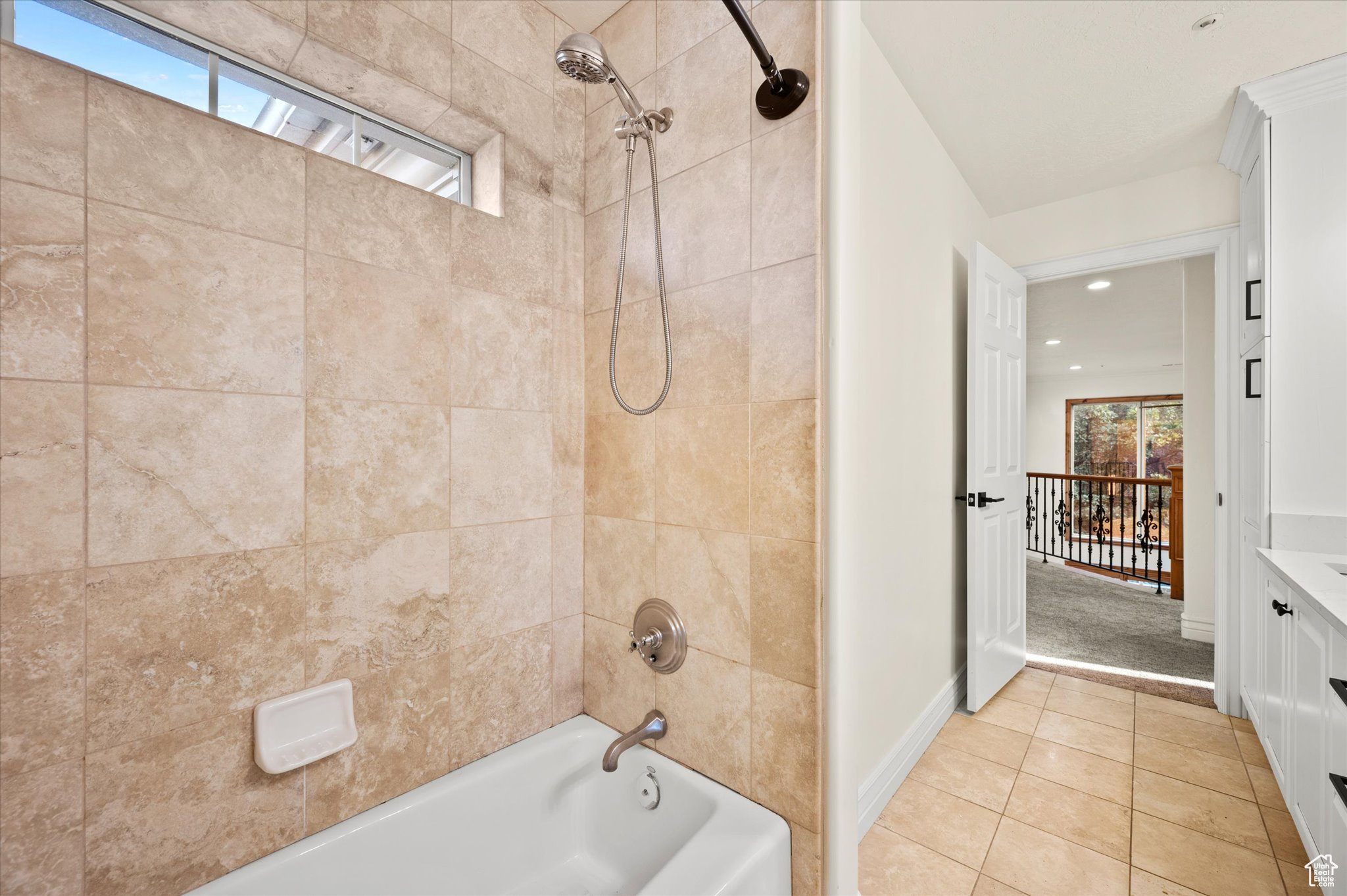 Bathroom featuring tile patterned floors, tiled shower / bath combo, and vanity