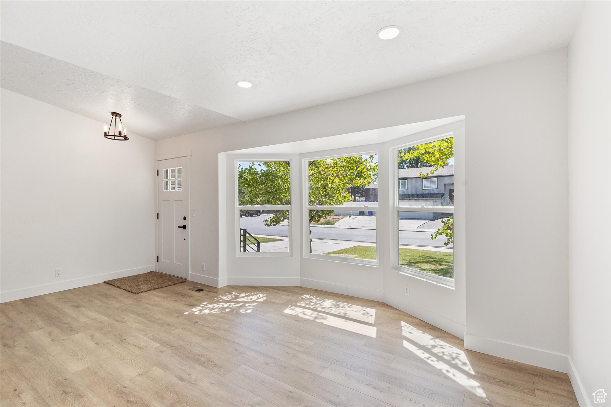 Doorway to outside with a textured ceiling and light hardwood / wood-style floors