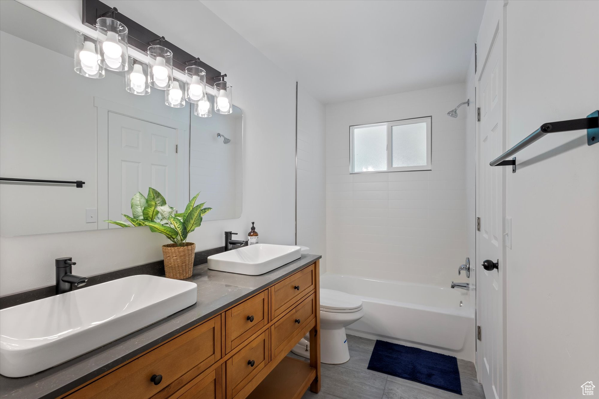 Full bathroom with vanity, toilet, and tiled shower / bath combo