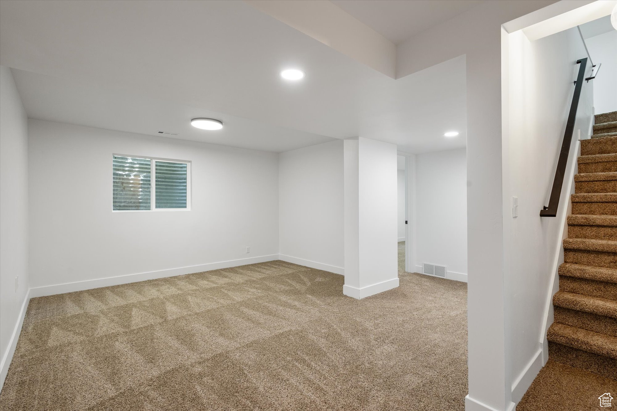 Basement featuring light carpet