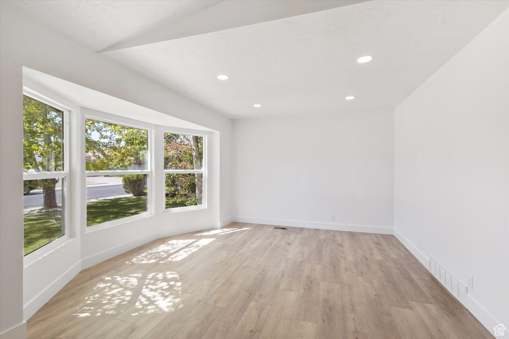 Unfurnished room with a healthy amount of sunlight and light wood-type flooring