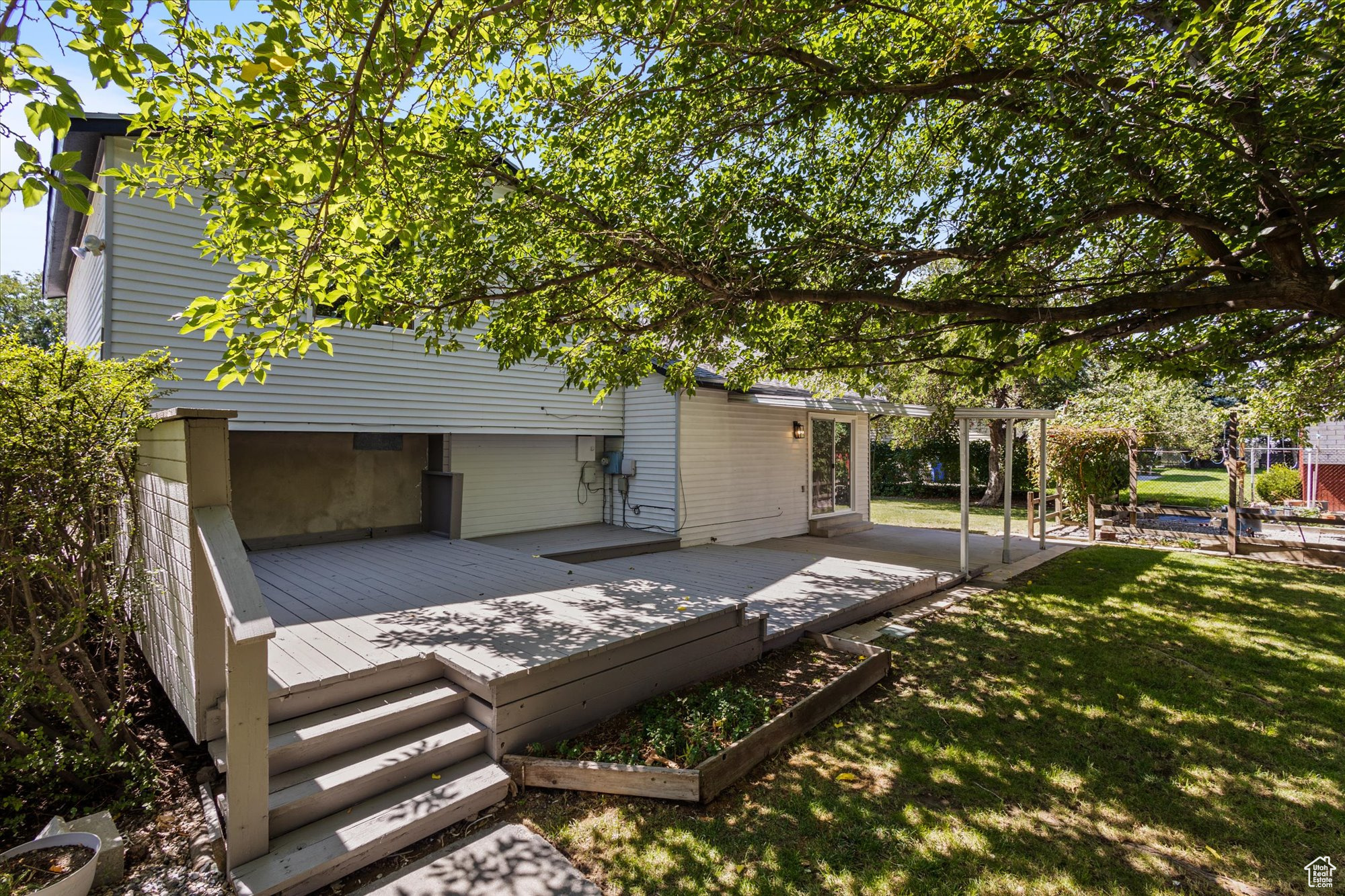 Back of house featuring a wooden deck and a lawn