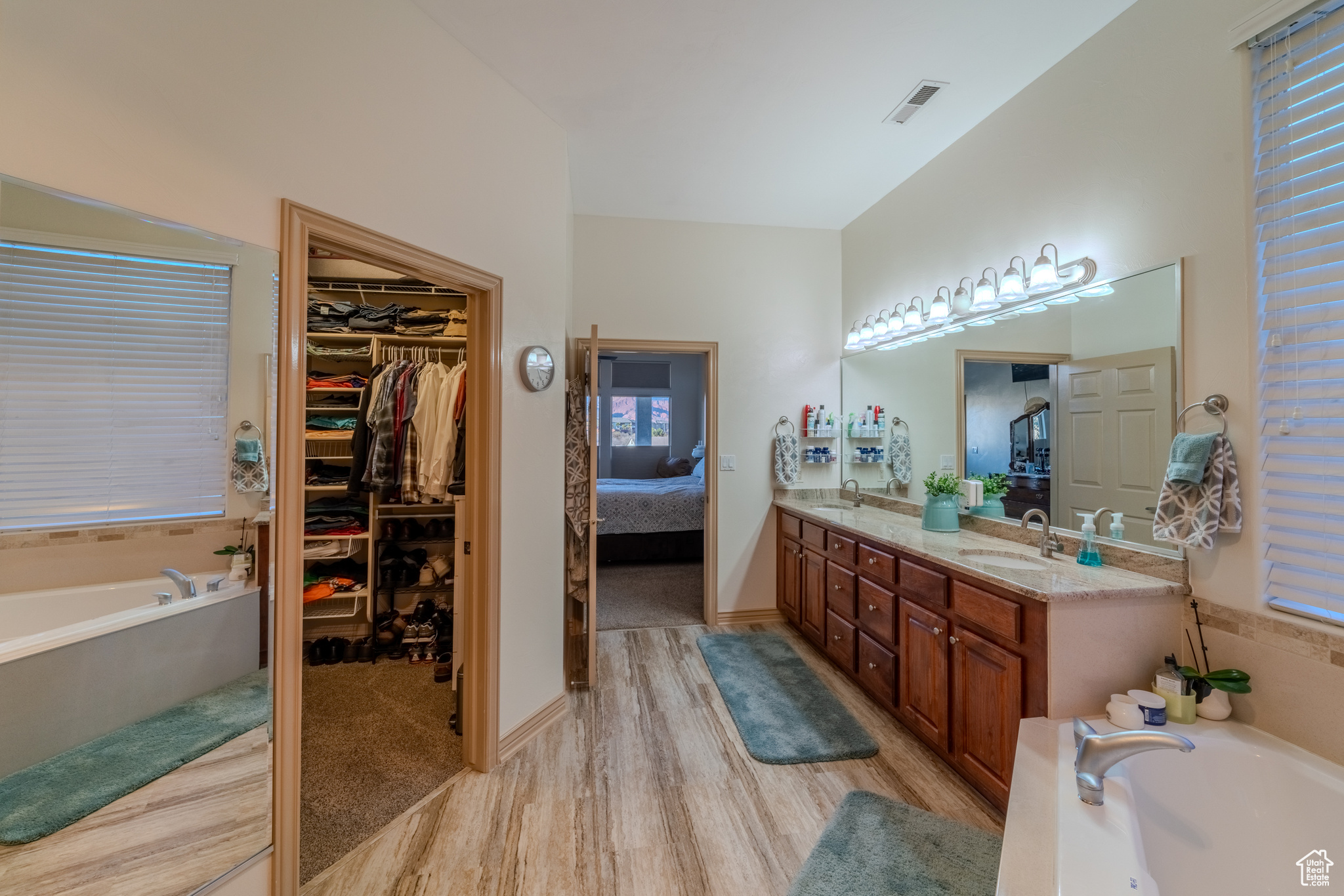 Bathroom with a bathtub, a wealth of natural light, wood-type flooring, and vanity