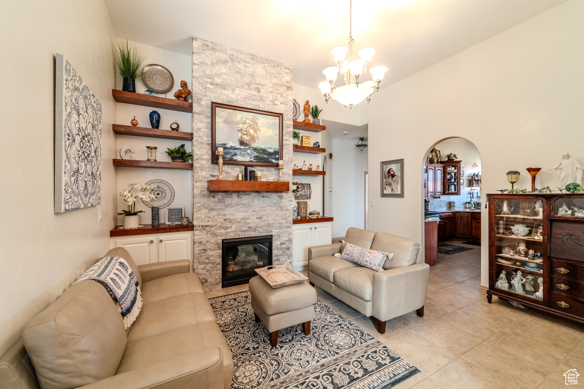 Tiled living room featuring a fireplace and a chandelier