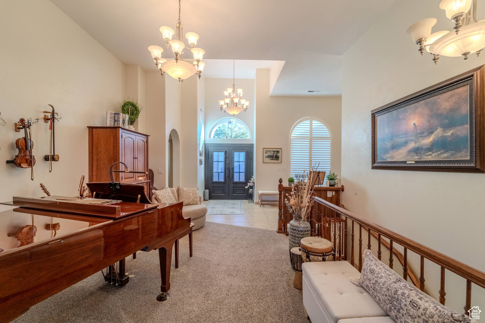 Interior space with carpet flooring, a notable chandelier, and french doors