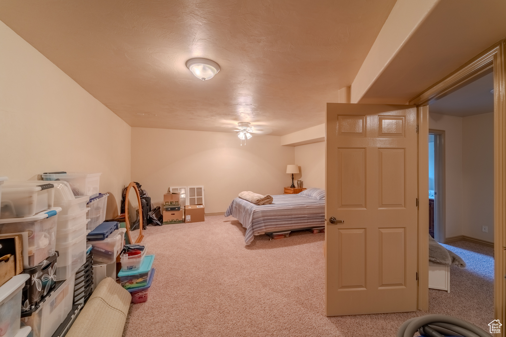 Carpeted bedroom featuring ceiling fan