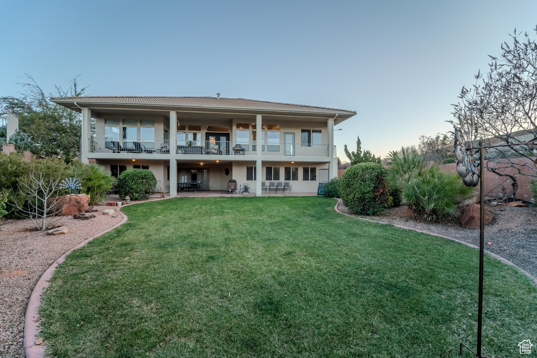 Back of property featuring a lawn and a balcony