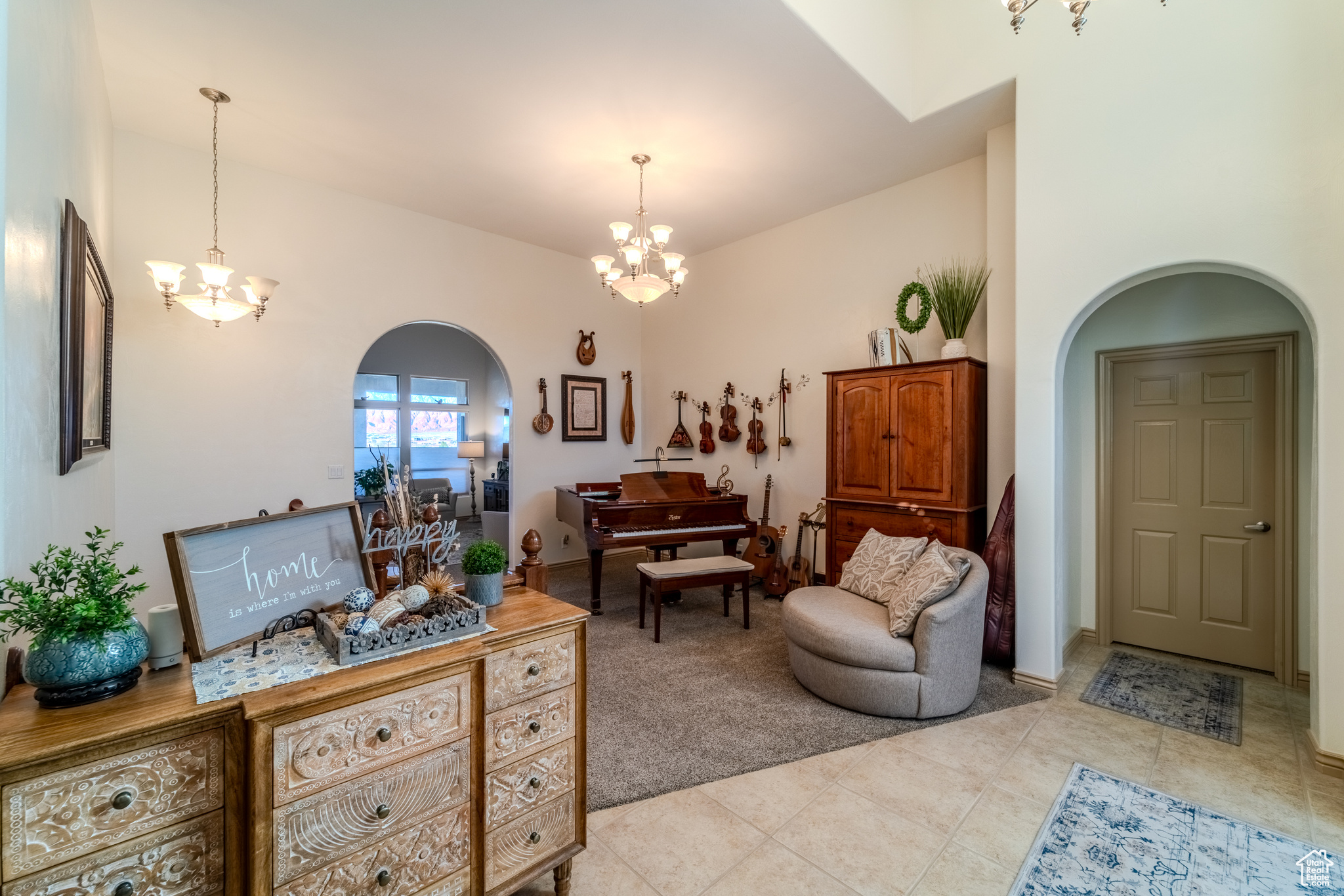 Living room with light tile patterned floors and an inviting chandelier