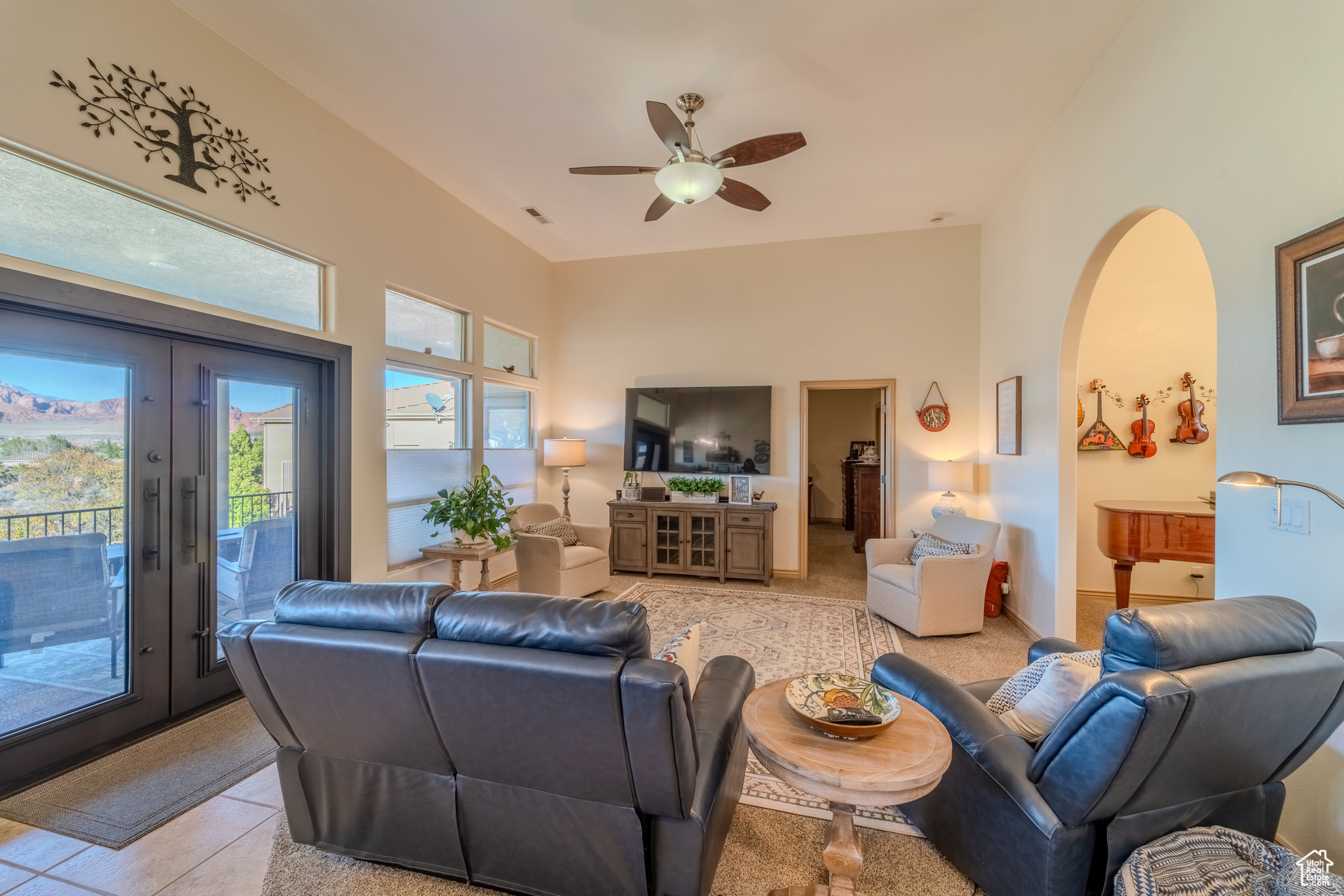 Living room with ceiling fan, french doors, and light tile patterned flooring